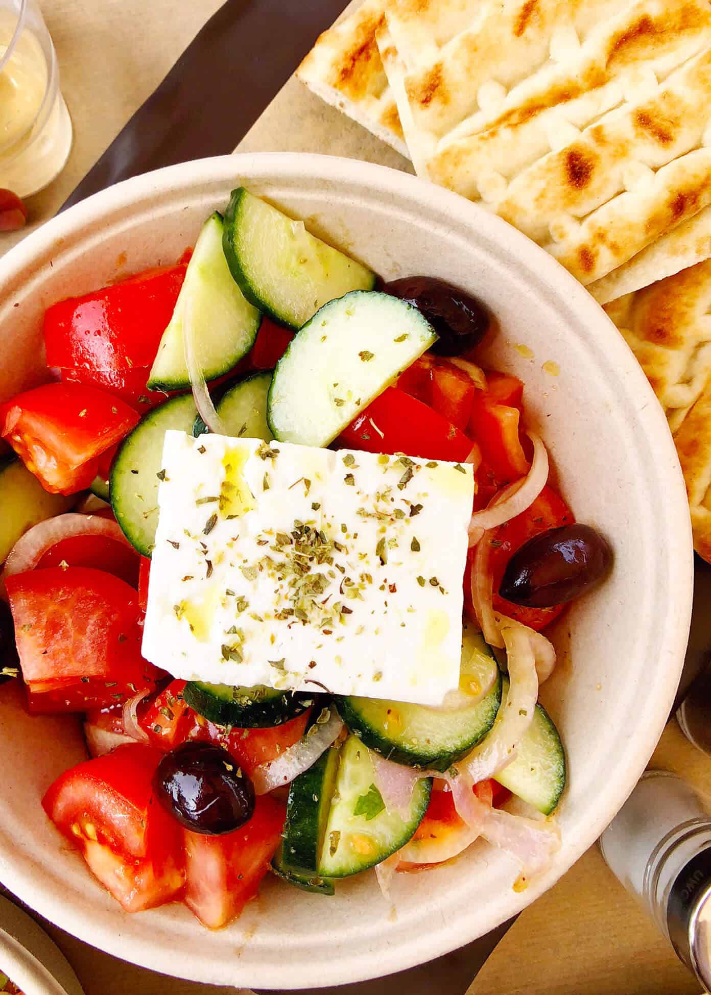 The Gimme Some Oven travel guide for restaurants to eat, hotels to stay and places to visit in Santorini, Greece. | Gimme Some Oven #santorini #greece #travel #traveltips #europe #vacation #islands #hotel #restaurant Greek Salad and Pita at PitoGyros in Santorini, Greece
