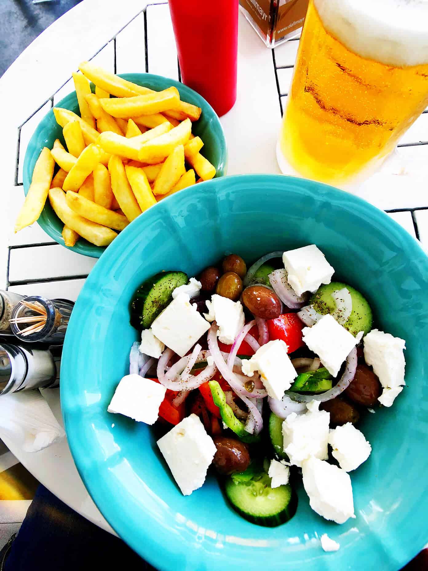 The Gimme Some Oven travel guide for restaurants to eat, hotels to stay and places to visit in Santorini, Greece. | Gimme Some Oven #santorini #greece #travel #traveltips #europe #vacation #islands #hotel #restaurant Greek Salad, Fries and Beer in Santorini, Greece