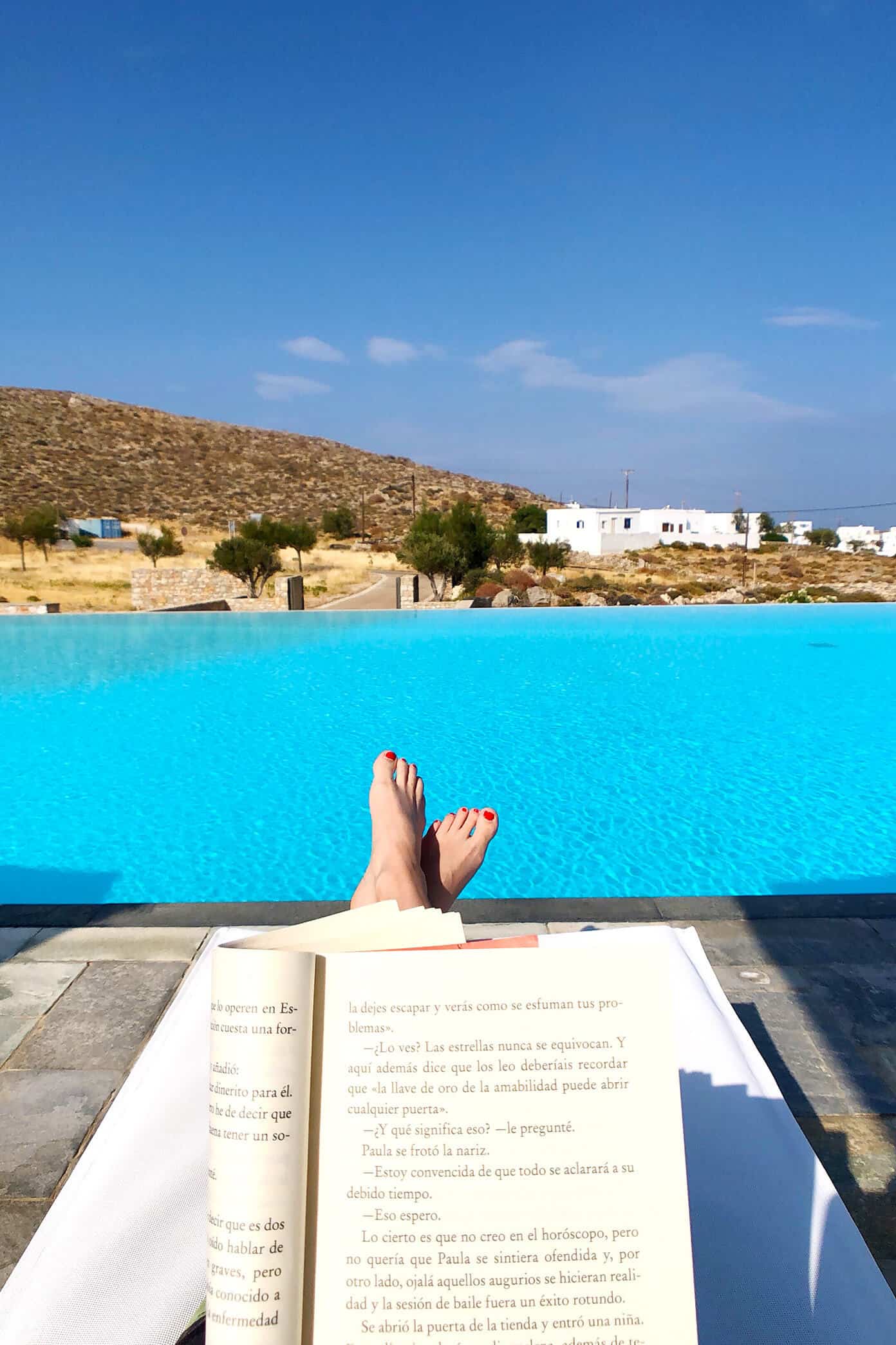 The Gimme Some Oven travel guide for restaurants to eat, hotels to stay and places to visit in Santorini, Greece. | Gimme Some Oven #santorini #greece #travel #traveltips #europe #vacation #islands #hotel #restaurant Reading by the pool at Anemi Hotel in Folegandros, Greece
