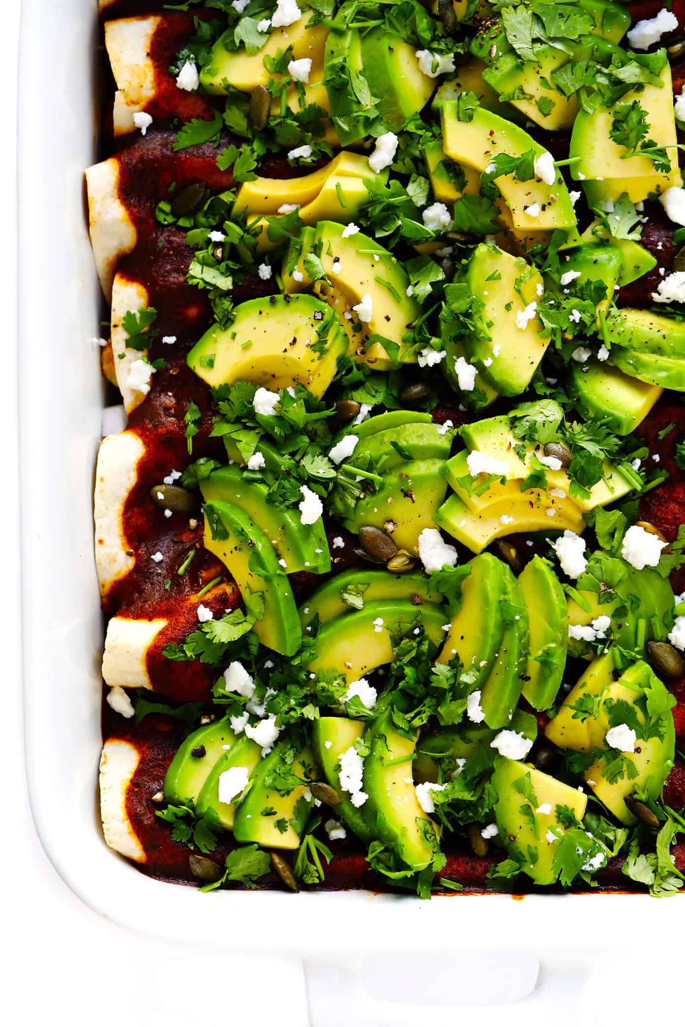 LOVE Roasted Cauliflower Enchiladas recipe! This vegetarian enchiladas recipe is full of caramelized roasted cauliflower, beans, cheese, and made with the best homemade enchilada sauce. Then it's loaded up with avocado, cilantro and all of your favorite toppings. It's the perfect Mexican dinner, and also makes great leftovers for meal prep! | Gimme Some Oven #cauliflower #enchiladas #mexican #dinner #mealprep #freezermeals #vegetarian Roasted Cauliflower Enchiladas Recipe with Avocado