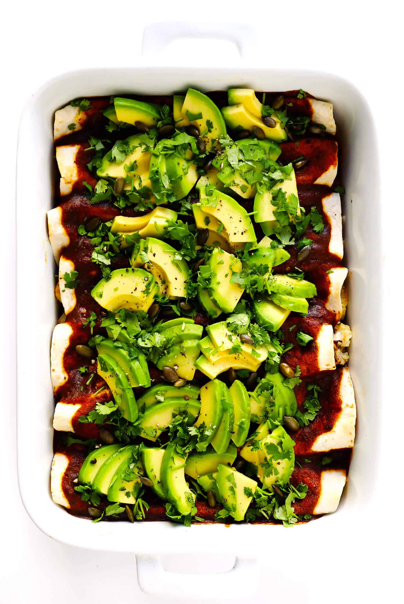 LOVE Roasted Cauliflower Enchiladas recipe! This vegetarian enchiladas recipe is full of caramelized roasted cauliflower, beans, cheese, and made with the best homemade enchilada sauce. Then it's loaded up with avocado, cilantro and all of your favorite toppings. It's the perfect Mexican dinner, and also makes great leftovers for meal prep! | Gimme Some Oven #cauliflower #enchiladas #mexican #dinner #mealprep #freezermeals #vegetarian Roasted Cauliflower Enchiladas Recipe with Avocado and Cilantro