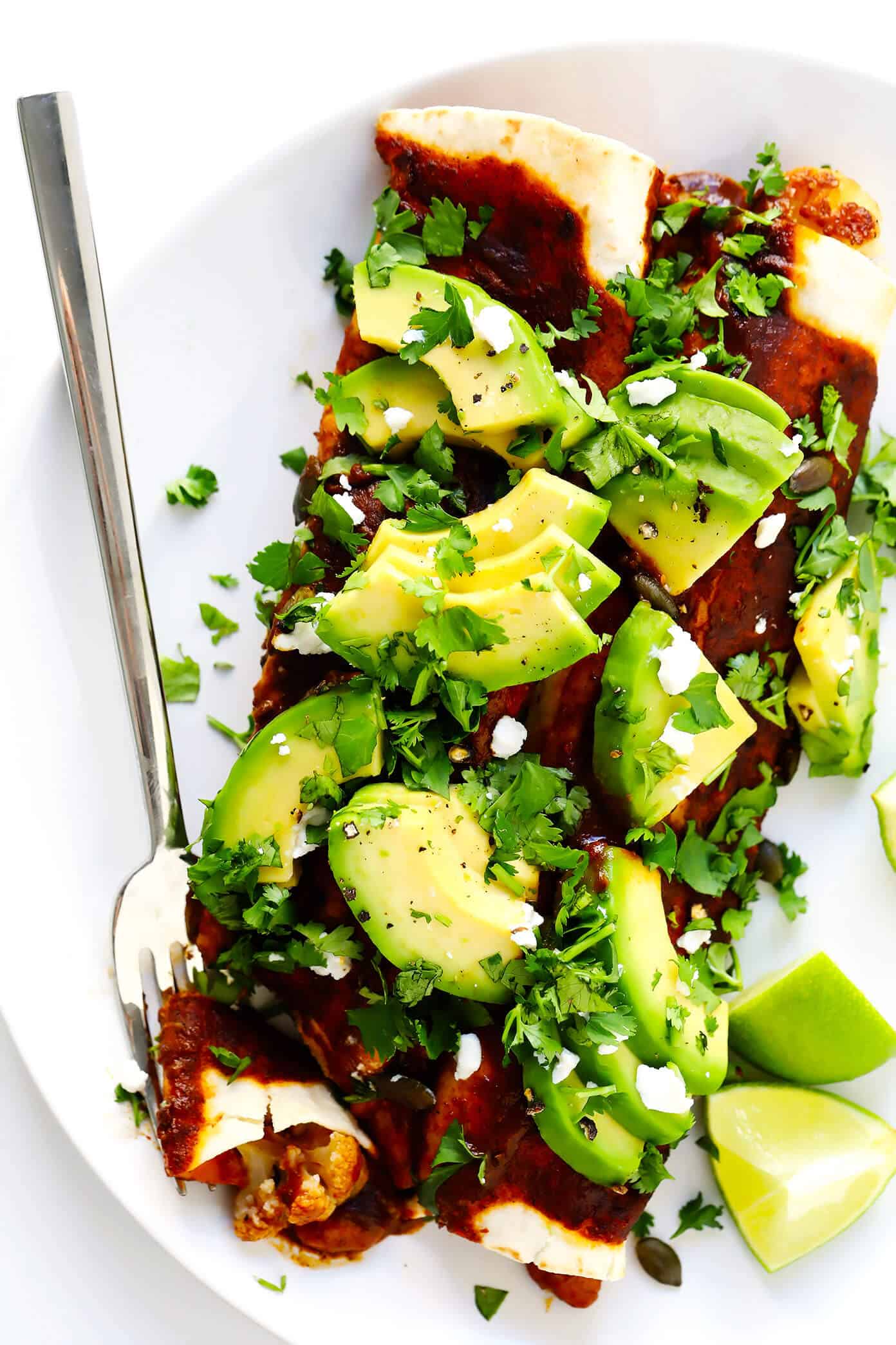 LOVE Roasted Cauliflower Enchiladas recipe! This vegetarian enchiladas recipe is full of caramelized roasted cauliflower, beans, cheese, and made with the best homemade enchilada sauce. Then it's loaded up with avocado, cilantro and all of your favorite toppings. It's the perfect Mexican dinner, and also makes great leftovers for meal prep! | Gimme Some Oven #cauliflower Vegetarian Roasted Cauliflower Enchiladas Recipe with Avocado