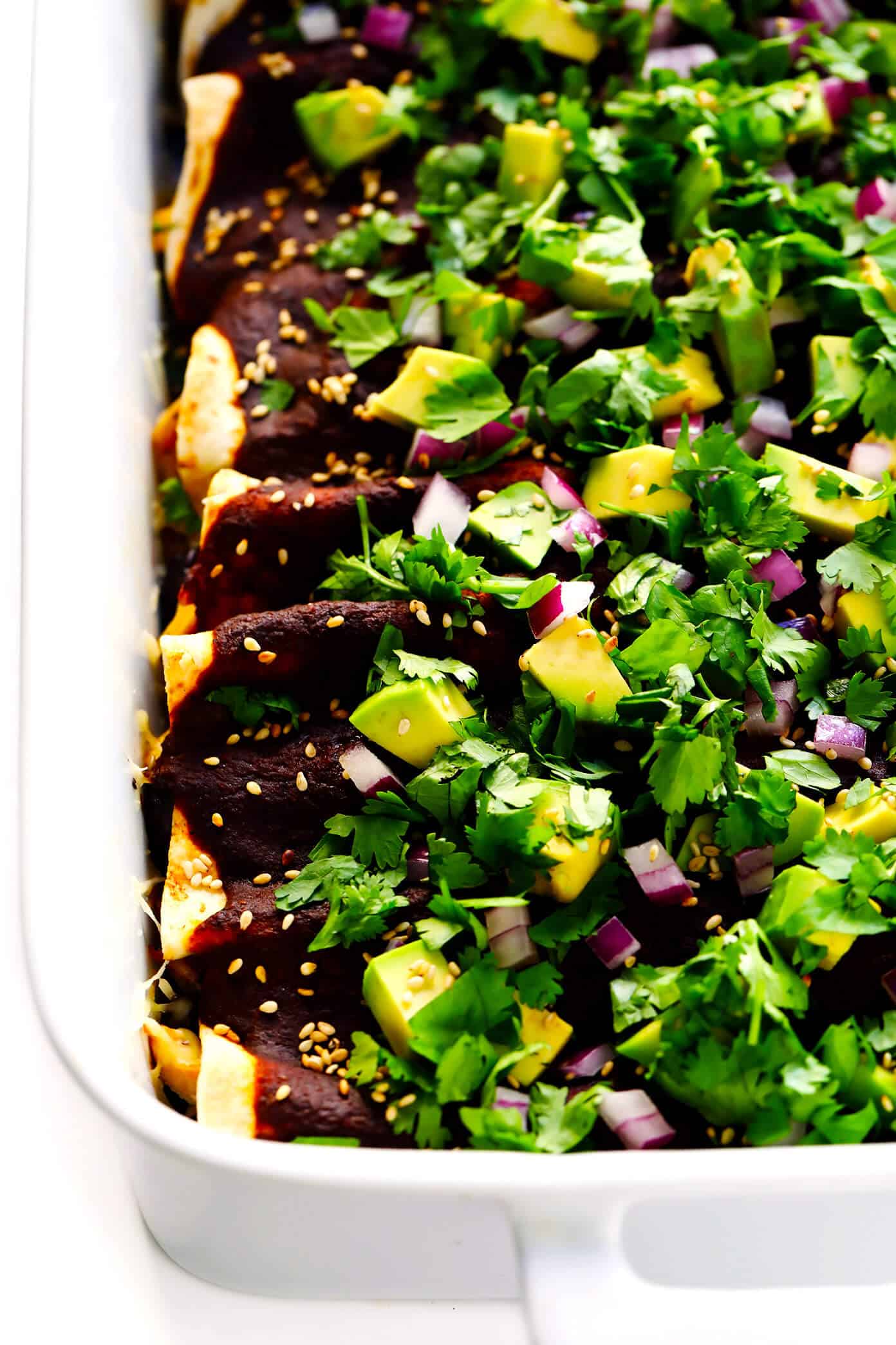 LOVE these mole enchiladas! They are made with the most delicious 20-minute homemade mole sauce, loaded up with your choice of fillings (chicken, carnitas, roasted veggies, beans, cheese, etc.), and garnished with lots of fresh toppings (avocado, cilantro, etc.). A delicious Mexican dinner that's sure to be a hit! | Gimme Some Oven #mole #enchiladas #mexican #dinner #vegetarian #glutenfree #chicken #avocado #mealprep #freezermeals Holy Mole Enchiladas | Made with chicken, carnitas, or your choice of vegetarian fillings