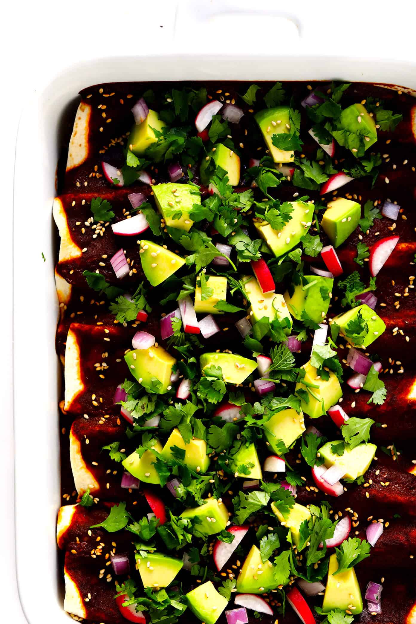 LOVE these mole enchiladas! They are made with the most delicious 20-minute homemade mole sauce, loaded up with your choice of fillings (chicken, carnitas, roasted veggies, beans, cheese, etc.), and garnished with lots of fresh toppings (avocado, cilantro, etc.). A delicious Mexican dinner that's sure to be a hit! | Gimme Some Oven #mole #enchiladas #mexican #dinner #vegetarian #glutenfree #chicken #avocado #mealprep #freezermeals Holy Mole Enchiladas