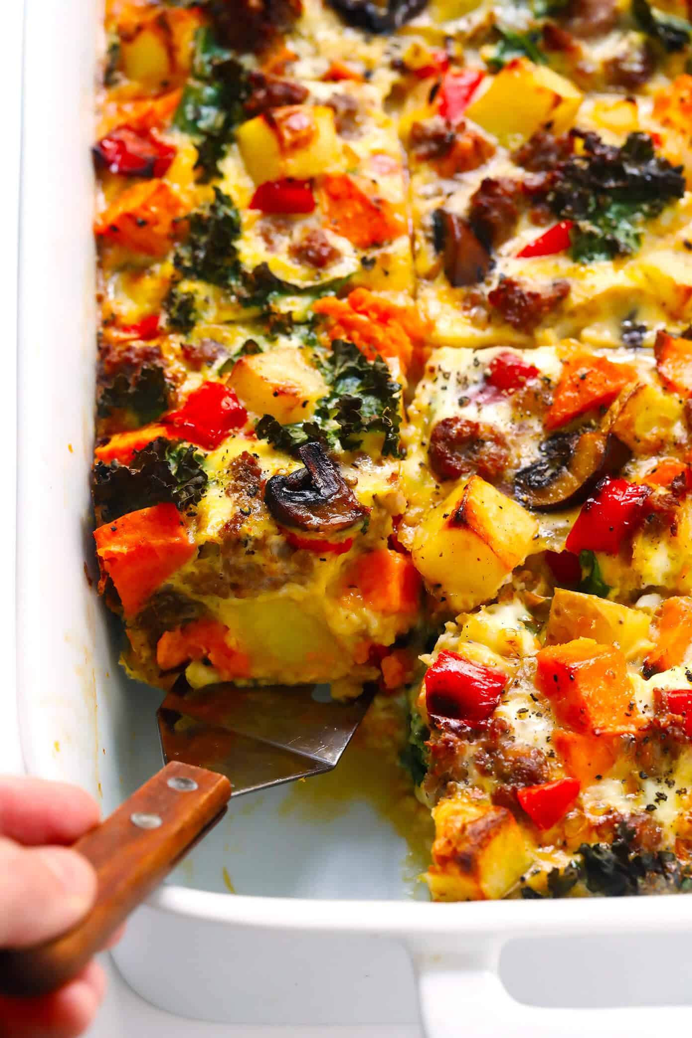 This Cozy Autumn Breakfast Casserole recipe is filled with roasted seasonal veggies (sweet potato, mushrooms, kale and more), sausage (or you can make yours vegetarian), eggs, and a zesty garlic seasoning. Perfect for the holidays, or any fall day that you're craving a delicious brunch. | Gimme Some Oven #breakfast #casserole #glutenfree #holiday #thanksgiving #christmas #fall #autumn #brunch #sausage #egg #glutenfree #makeahead Cozy Autumn Breakfast Casserole Recipe with Sweet Potato