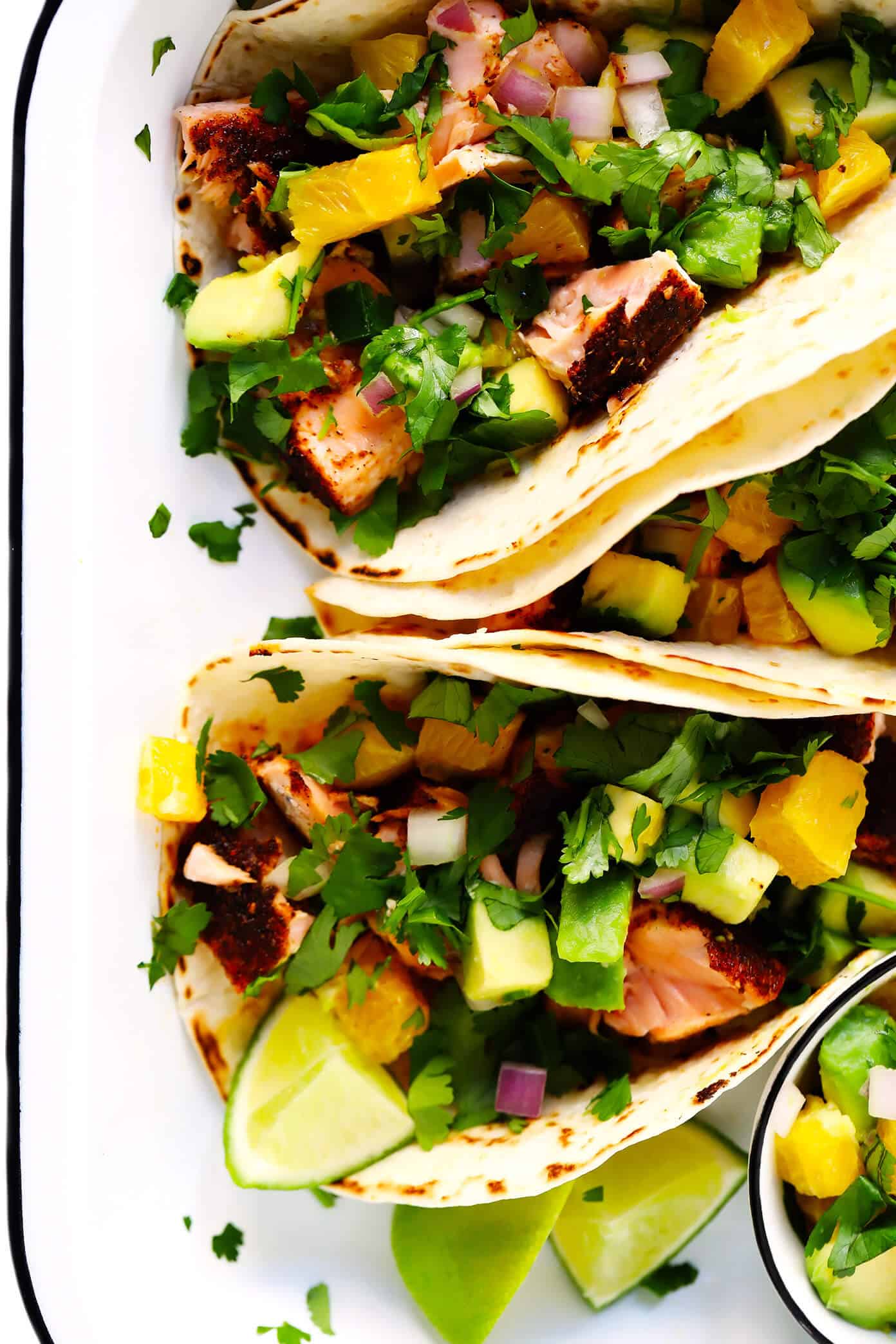 These Super-Simple Salmon Tacos are topped with a juicy fresh orange avocado salsa, seasoned with a zesty chili rub, and can be on the table in just 30 minutes. A delicious, quick, easy and healthy dinner recipe that everyone will love! | gimmesomeoven.com #salmon #tacos #mexican #fish #glutenfree #salsa #dinner #healthy Salmon Tacos with Orange Avocado Salsa
