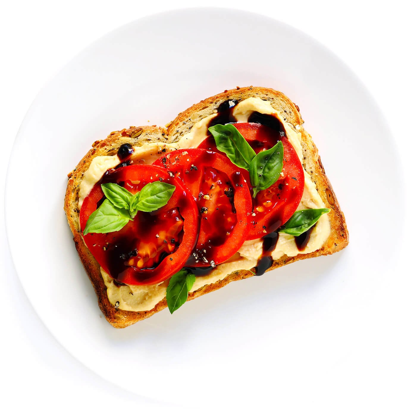 Hummus Toast is fun to customize with your favorite toppings, and makes for a delicious easy breakfast, lunch, dinner or healthy snack! Read more for details on 8 of our favorite toppings -- "everything", avocado, elote, tomato basil, lox, fried egg, mediterranean or honey banana. | gimmesomeoven.com #hummus #toast #healthy #breakfast #dinner #lunch #snack Tomato Basil Hummus Toast