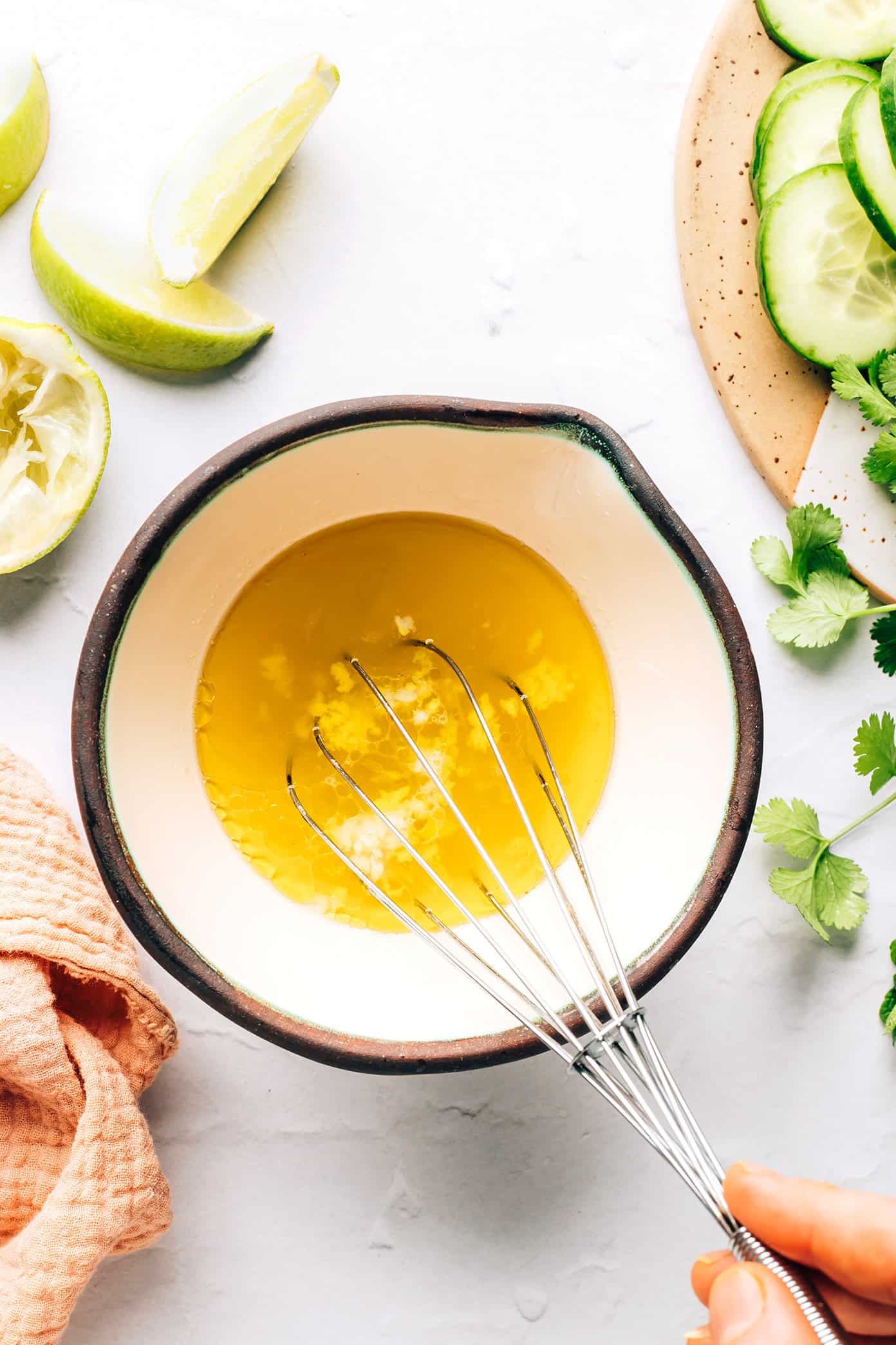 This Thai cucumber salad recipe is loaded up with fresh cucumbers, onions, herbs and peanuts and tossed with a quick zesty lime dressing. It's the perfect cold side dish, and it's naturally gluten-free and can be made vegetarian/vegan too. | gimmesomeoven.com Mixing Lime Dressing for Thai Cucumber Salad