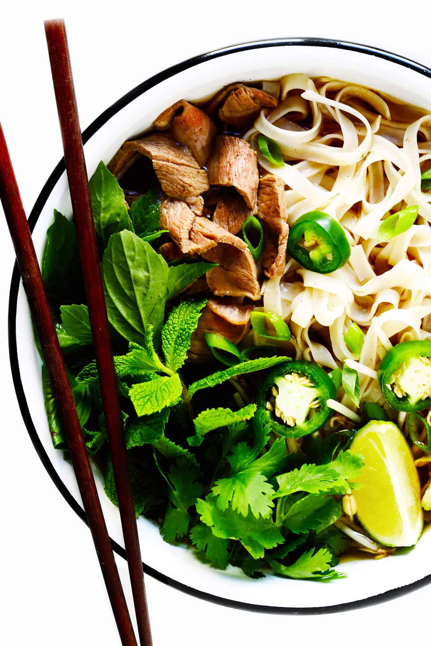 This homemade Vietnamese pho recipe is made with a rich and savory broth, rice noodles, beef (or chicken, pork or shrimp), and then loaded up with lots of fresh herbs and toppings. Always a delicious dinner idea when you're craving a big bowl of soup, and it's naturally gluten-free too! | gimmesomeoven.com Pho Soup with Beef, Chicken, Pork or Shrimp