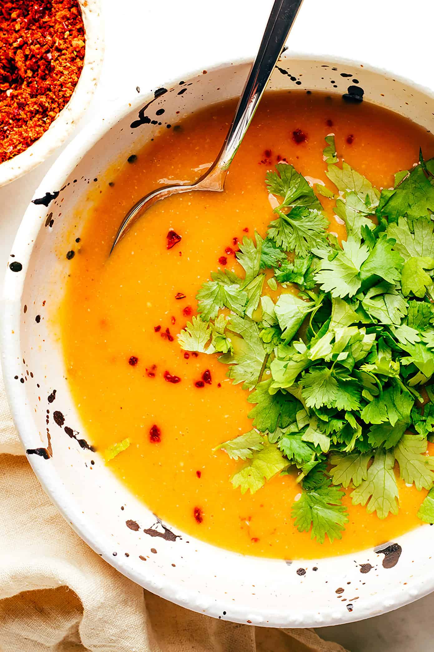 This Turkish Lentil Soup recipe (mercimek çorbası) tastes wonderfully light and fresh, and it's easy to make in less than 30 minutes. One of my favorite healthy vegetarian dinner recipes! | gimmesomeoven.com Closeup bowl of Turkish lentil soup with cilantro
