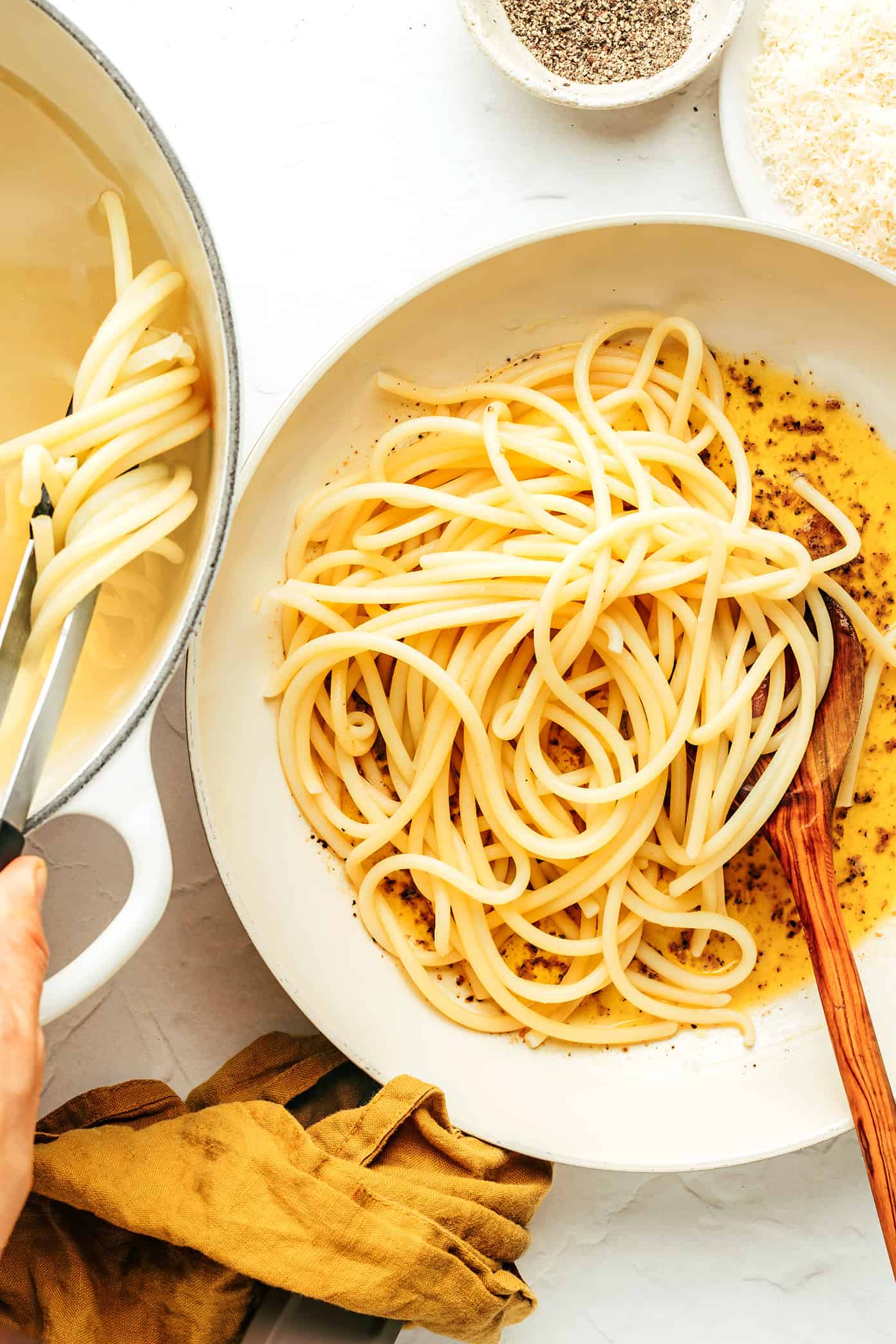 My favorite cacio e pepe recipe is easy to make in about 30 minutes with just 4 simple ingredients -- pasta, cheese (Pecorino, or a blend with Parmesan), guanciale and a hint of butter. Such an easy dinner and always the best Italian comfort food! | gimmesomeoven.com Mixing pasta into cacio e pepe sauce