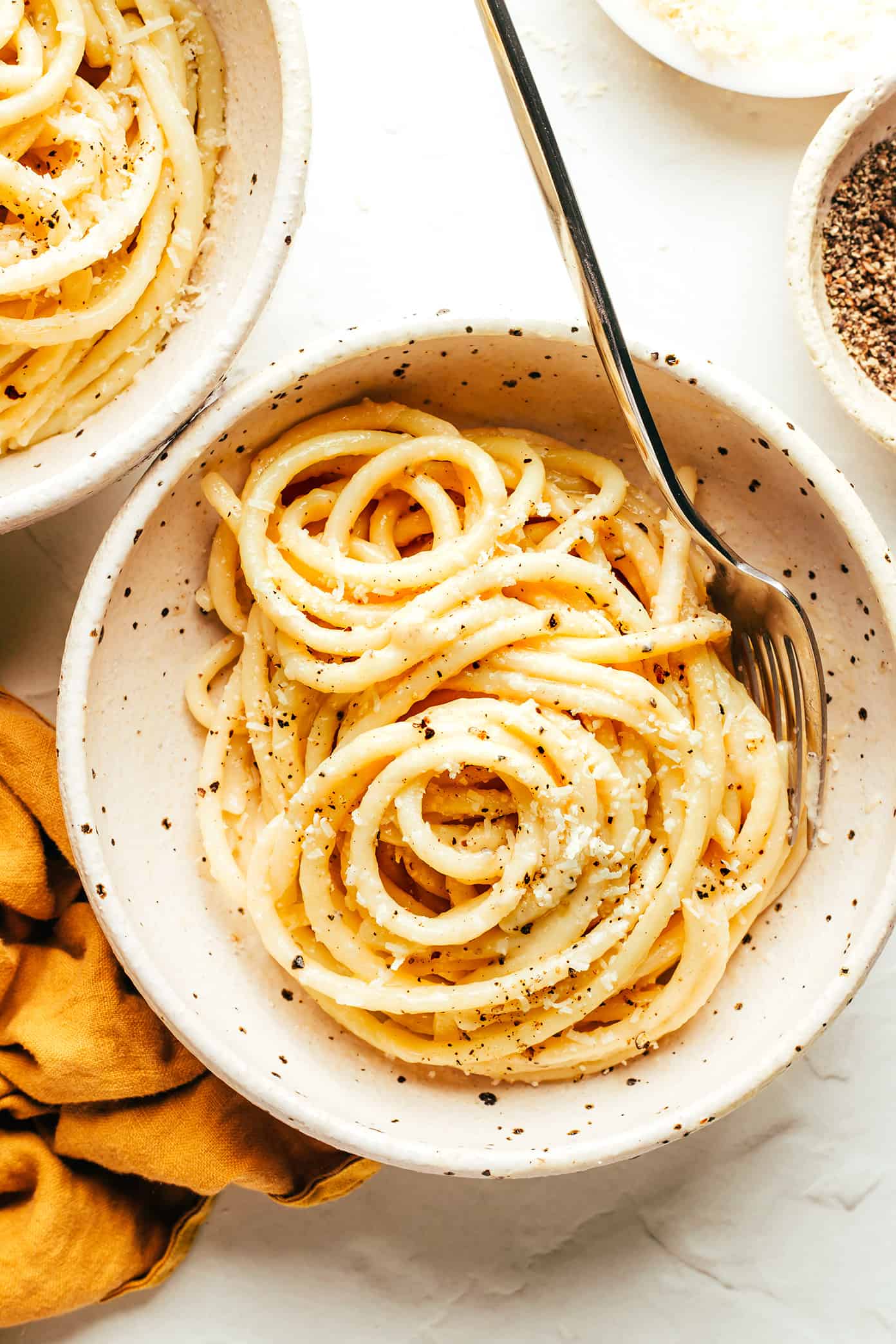 My favorite cacio e pepe recipe is easy to make in about 30 minutes with just 4 simple ingredients -- pasta, cheese (Pecorino, or a blend with Parmesan), guanciale and a hint of butter. Such an easy dinner and always the best Italian comfort food! | gimmesomeoven.com Bucatini Cacio e Pepe in Serving Bowl