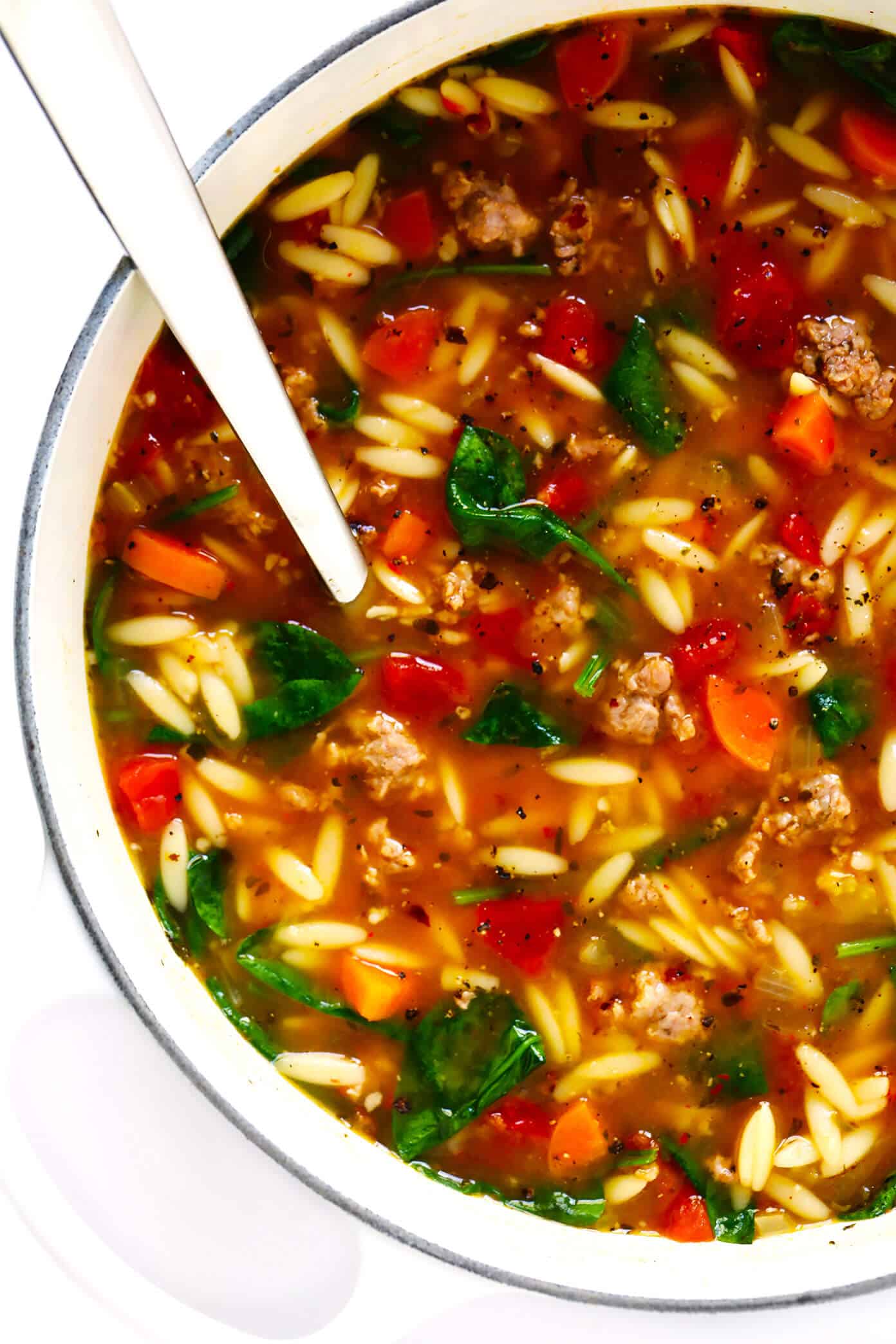 This Italian Sausage and Orzo Soup recipe is easy to make with your choice of veggies, it's seasoned with a zesty garlic tomato broth, and tastes SO cozy and comforting. The perfect easy dinner recipe that also makes great leftovers for later! | gimmesomeoven.com #italian #soup #pasta #orzo #sausage #dinner #freezermeal #mealprep #healthy Italian Sausage Orzo Soup