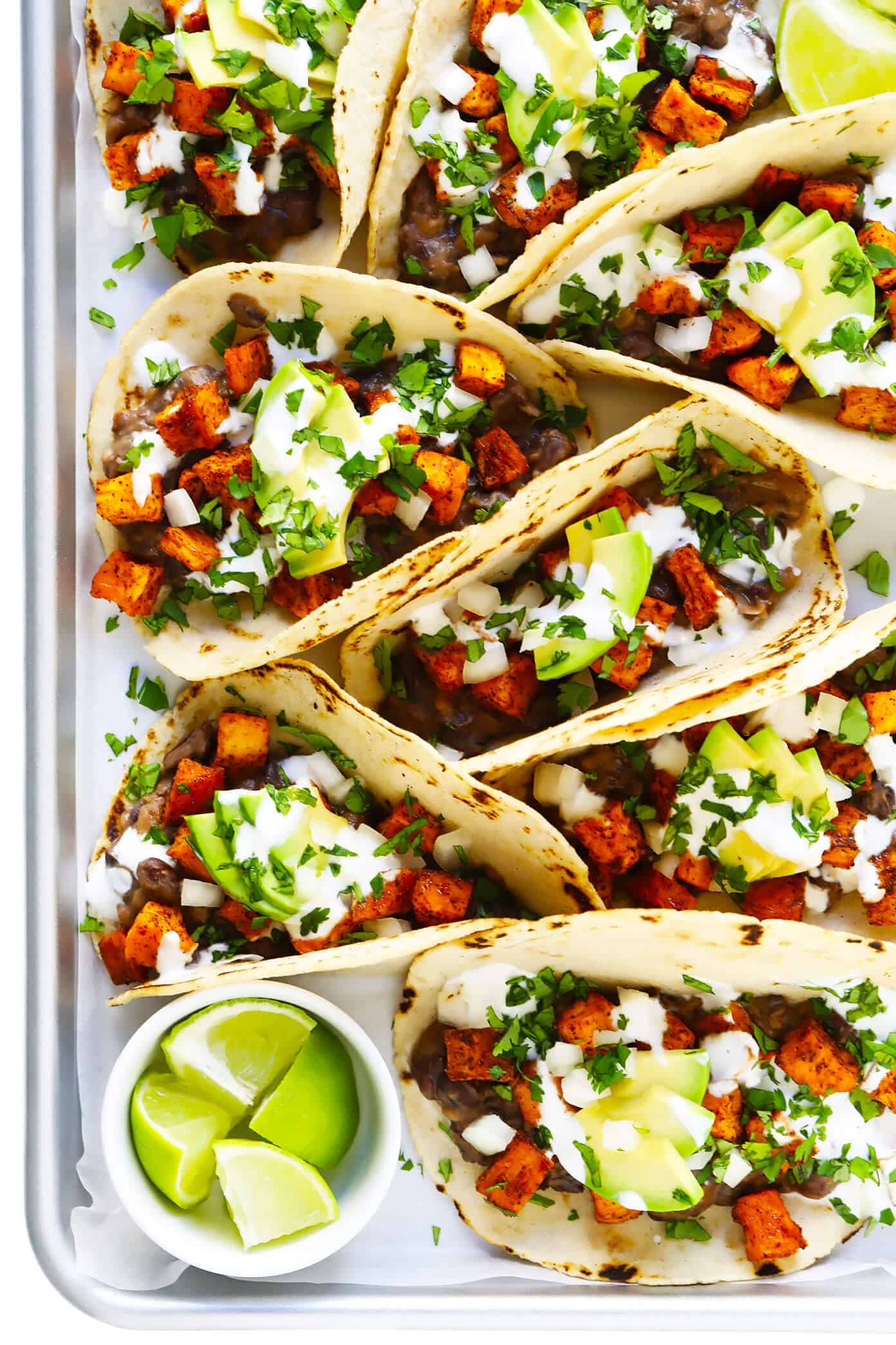 These zesty roasted sweet potato tacos are made with refried black beans, fresh avocado, lime crema, and your choice of toppings. Easy to make, naturally vegan and gluten-free, and SO delicious! | gimmesomeoven.com #tacos #sweetpotato #vegetarian #vegan #glutenfree #healthy #mexican #dinner #beans Roasted Sweet Potato Tacos