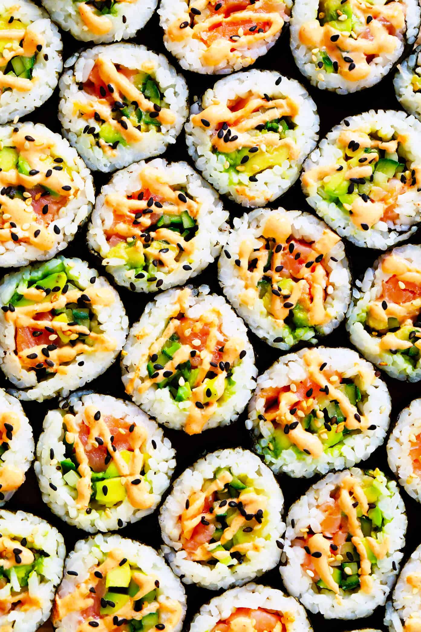 Learn how to make sushi rolls with this easy maki rolls recipe! They are surprisingly easy to make, and 100% customizable with whatever ingredients you love best. Spicy sriracha sauce recipe included if you would like to make spicy tuna, salmon or veggie rolls! | gimmesomeoven.com #sushi #rolls #maki #japanese #howto #salmon #vegetarian #vegan #healthy #dinner #entertaining Salmon Avocado Sushi Rolls with Spicy Sauce