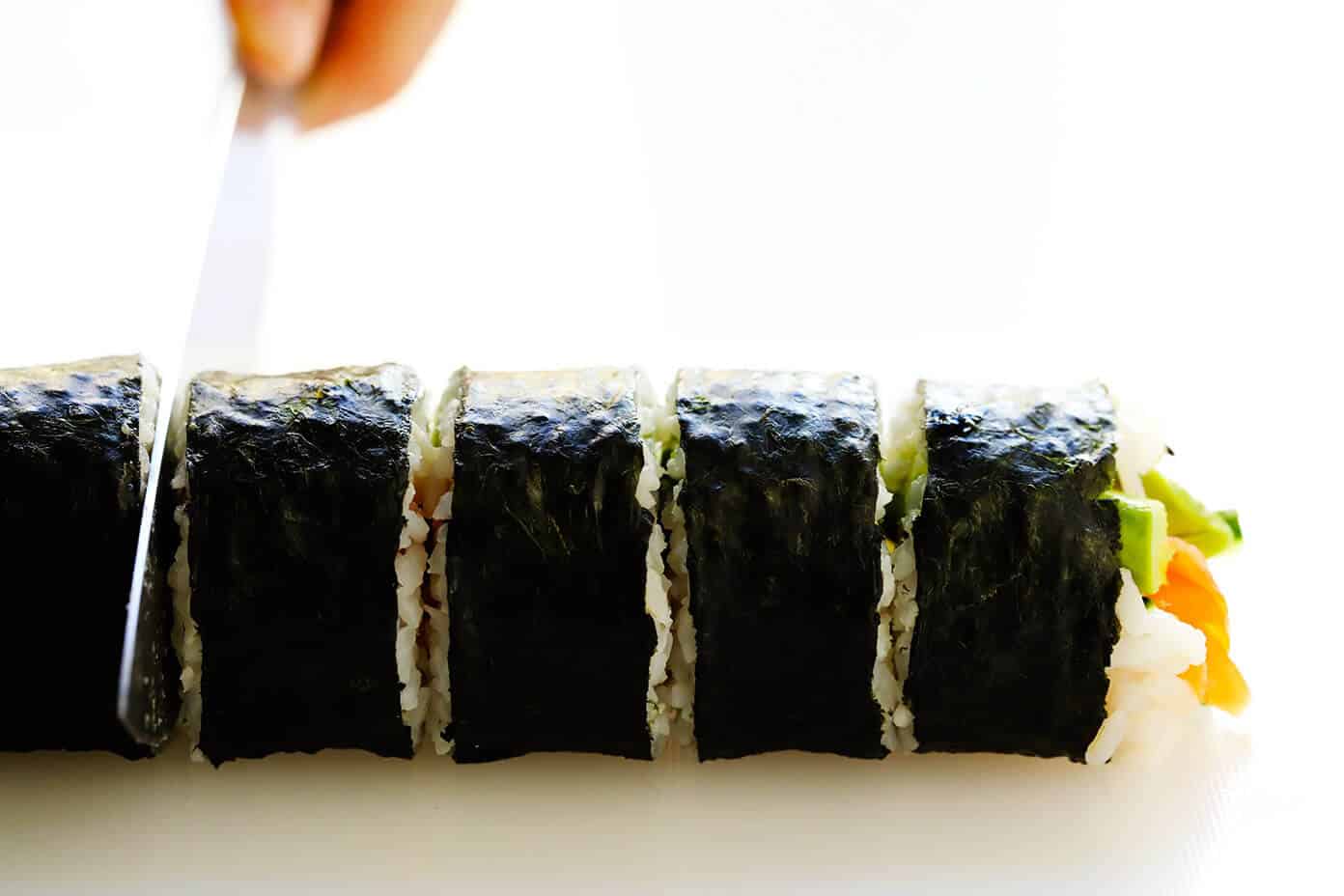 Learn how to make sushi rolls with this easy maki rolls recipe! They are surprisingly easy to make, and 100% customizable with whatever ingredients you love best. Spicy sriracha sauce recipe included if you would like to make spicy tuna, salmon or veggie rolls! | gimmesomeoven.com #sushi #rolls #maki #japanese #howto #salmon #vegetarian #vegan #healthy #dinner #entertaining How To Cut Sushi Rolls