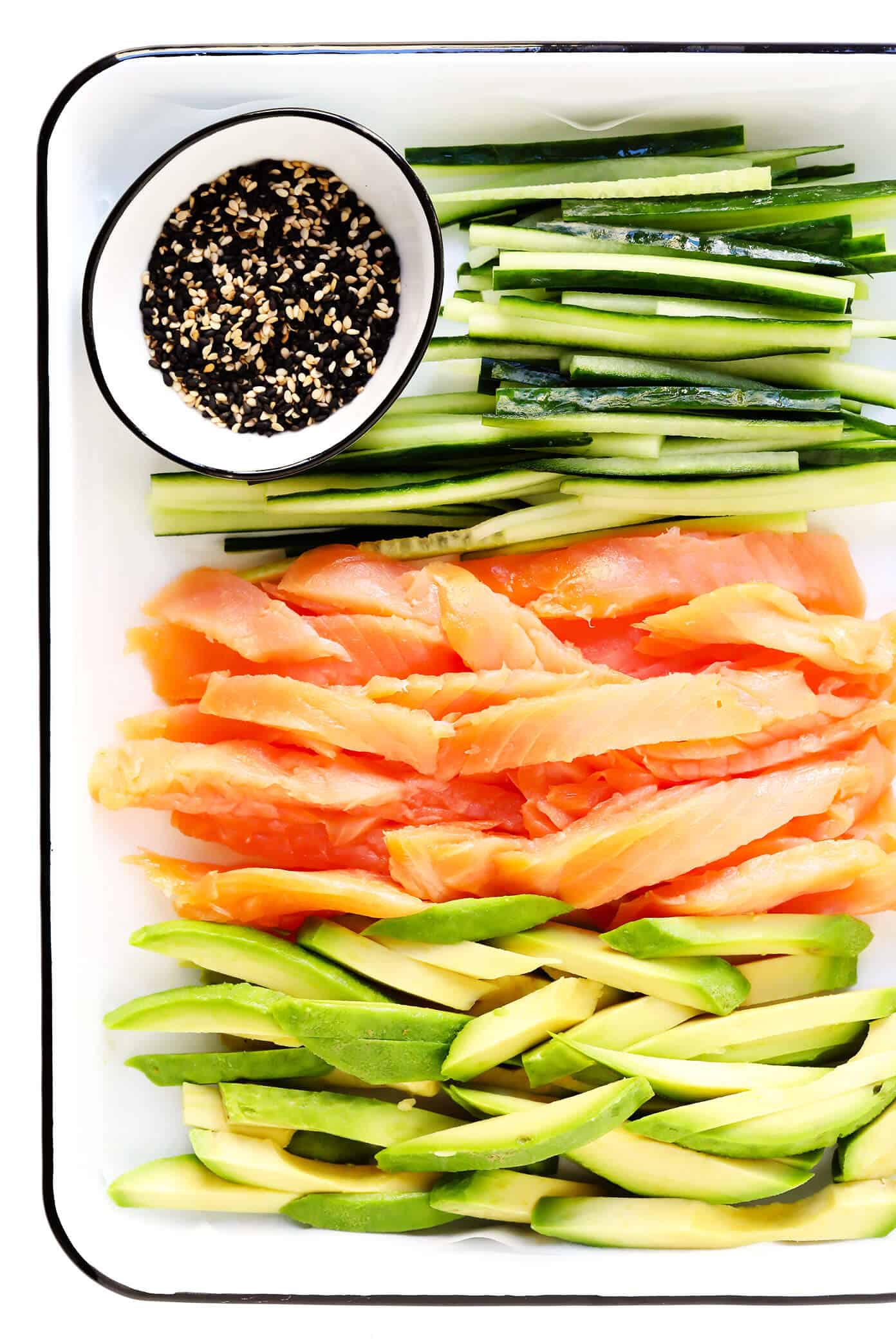 Learn how to make sushi rolls with this easy maki rolls recipe! They are surprisingly easy to make, and 100% customizable with whatever ingredients you love best. Spicy sriracha sauce recipe included if you would like to make spicy tuna, salmon or veggie rolls! | gimmesomeoven.com #sushi #rolls #maki #japanese #howto #salmon #vegetarian #vegan #healthy #dinner #entertaining Sushi Roll Ingredients -- Cucumber, Smoked Salmon, Avocado, Sesame Seeds