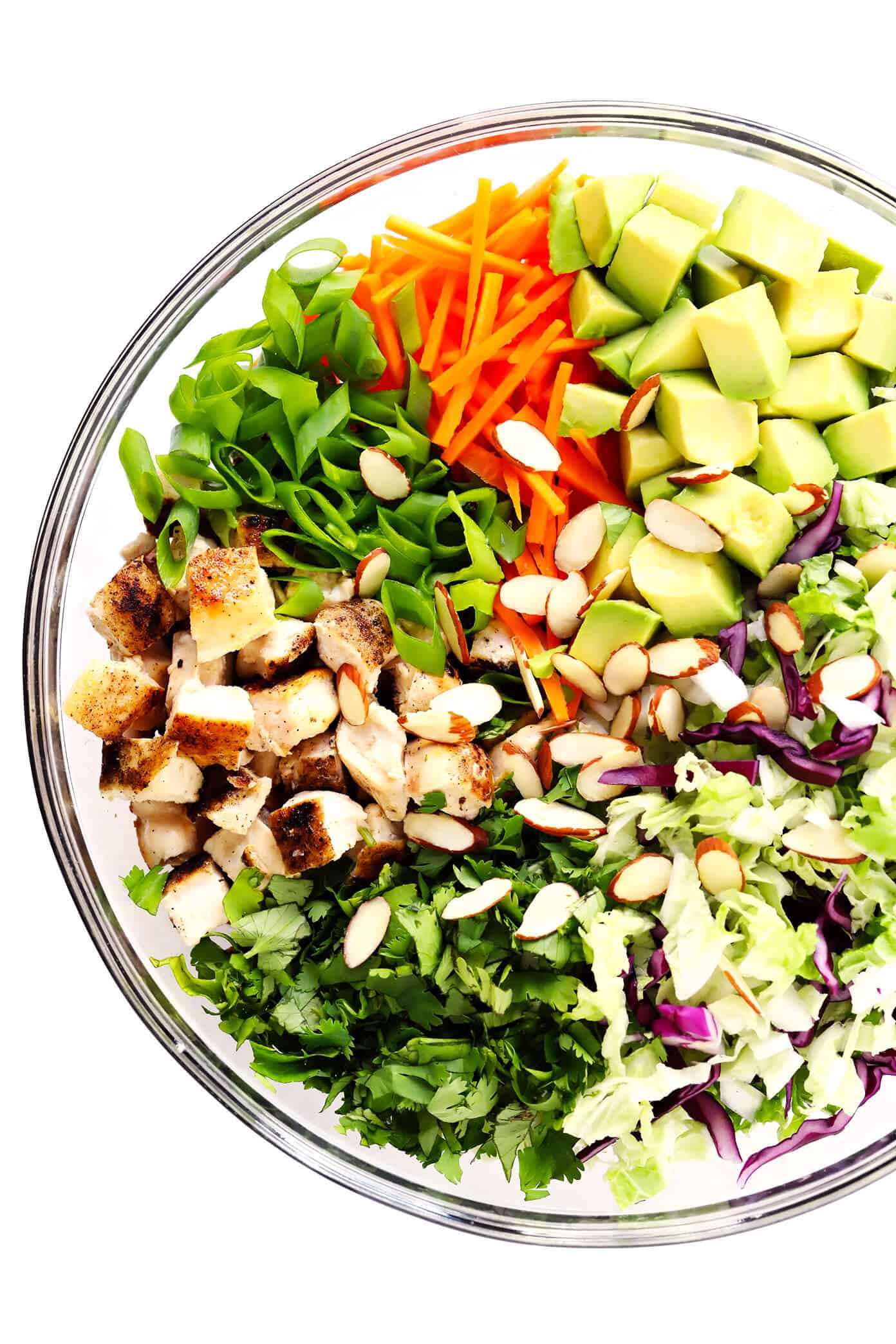 This Sesame Chicken Salad recipe is made with crisp cole slaw and carrots, zesty chicken, crunchy toasted almonds, creamy avocado, lots of fresh cilantro and a quick sesame soy vinaigrette. It's a simple salad recipe that always hits the spot! | gimmesomeoven.com #salad #sesame #asian #almond #avocado #chicken #vinaigrette #dressing #mealprep #healthy #glutenfree Sesame Chicken Salad Ingredients (Baked Chicken, Green Onions, Carrots, Cilantro, Cole Slaw, Avocado and Toasted Almonds)