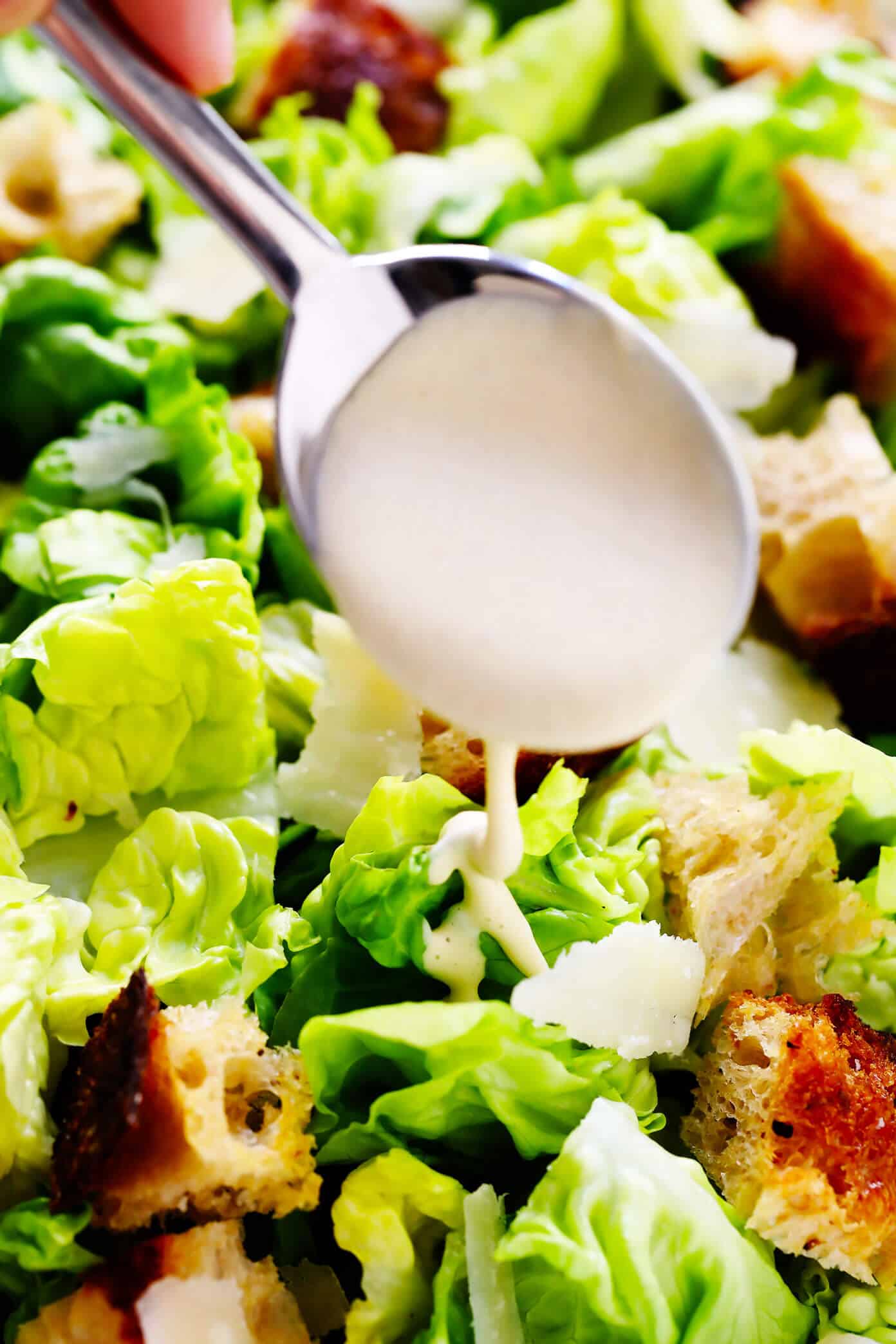 The BEST Caesar Dressing recipe -- quick and easy to make, full of the best creamy, savory, umami flavors, and downright irresistible on a classic Caesar salad. | gimmesomeoven.com #caesar #salad #dressing #creamy #italian #dinner #recipe Caesar Dressing Drizzled On Caesar Salad