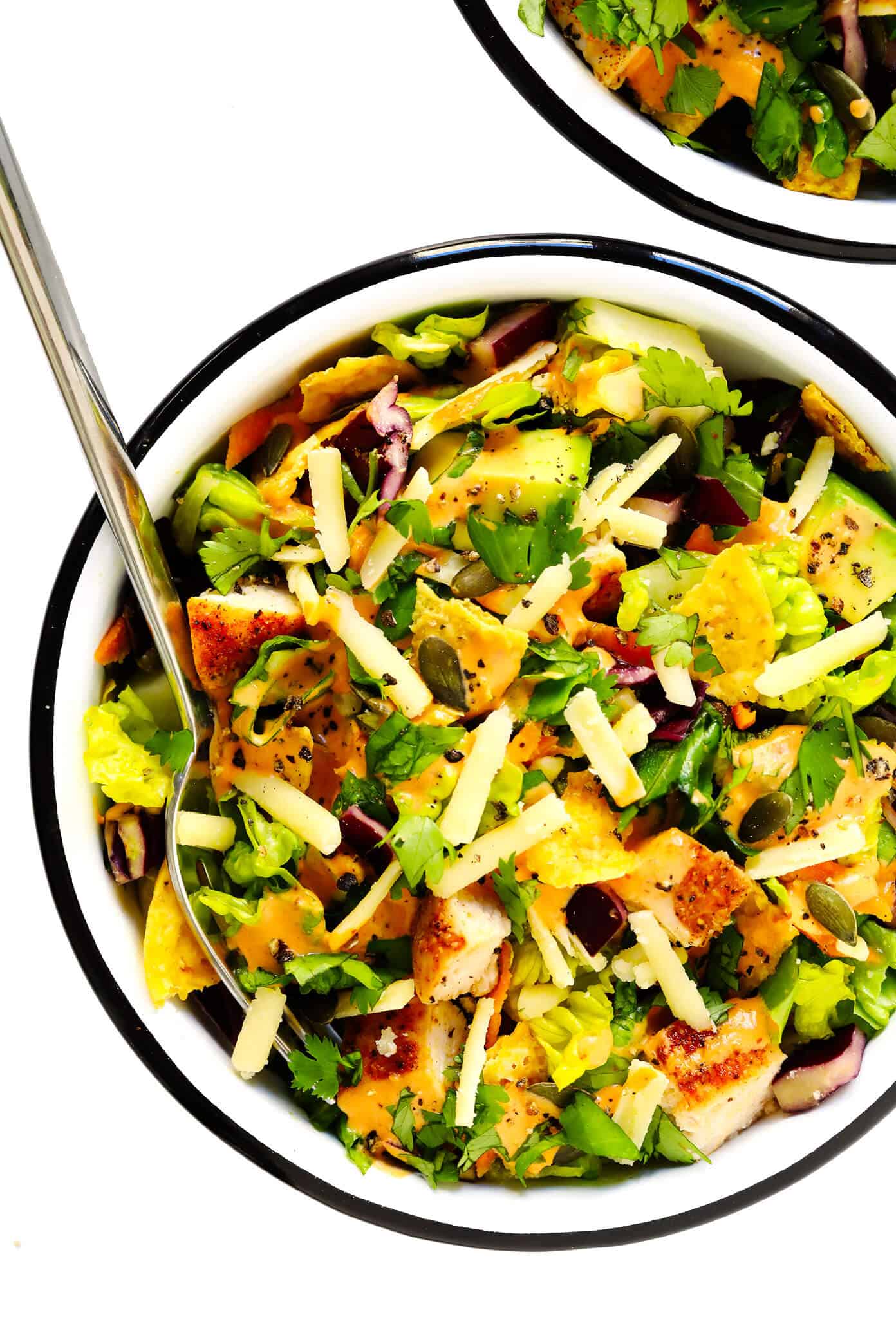 This chipotle cheddar chopped salad recipe is full of the most delicious mix of crunchy greens, sharp cheddar cheese, zesty chicken, fresh cilantro, creamy avocado, and a creamy chipotle honey lime dressing. | gimmesomeoven.com #salad #chipotle #healthy #chicken #avocado #glutenfree #dinner #mexican #texmex Chipotle Salad in Serving Bowls