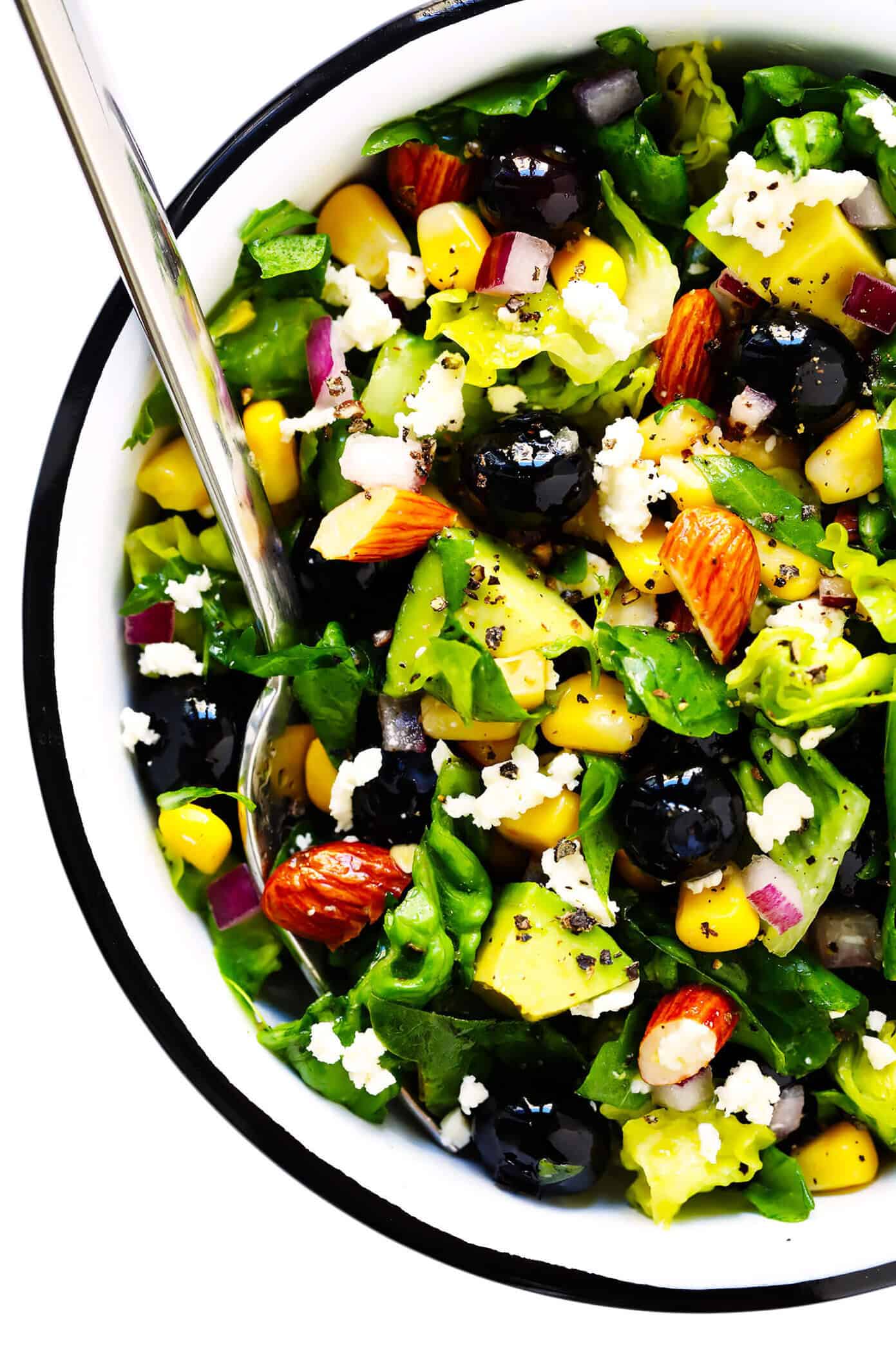 This Blueberry, Corn & Avocado Chopped Salad recipe is tossed with lots of fresh basil, toasted almonds, crumbled feta, red onions, and an easy lemon dressing. The perfect salad for summertime! | gimmesomeoven.com #salad #blueberry #corn #avocado #chopped #glutenfree #healthy #dinner #vegetarian #summer Serving bowl of corn, avocado and blueberry salad