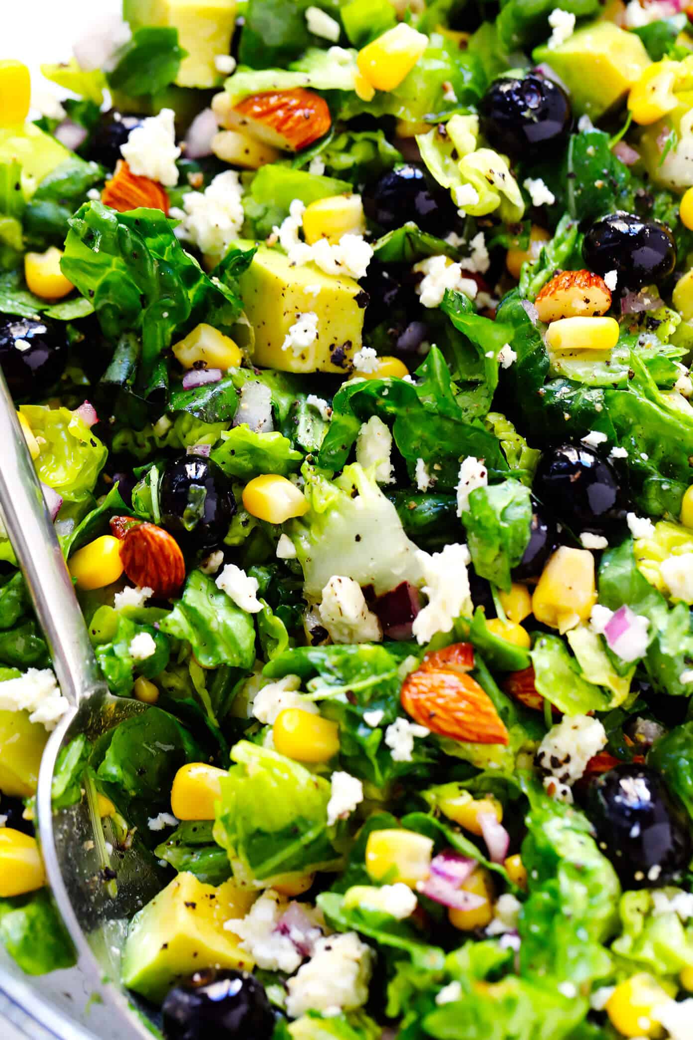 This Blueberry, Corn & Avocado Chopped Salad recipe is tossed with lots of fresh basil, toasted almonds, crumbled feta, red onions, and an easy lemon dressing. The perfect salad for summertime! | gimmesomeoven.com #salad #blueberry #corn #avocado #chopped #glutenfree #healthy #dinner #vegetarian #summer Closeup of blueberry, avocado and corn salad