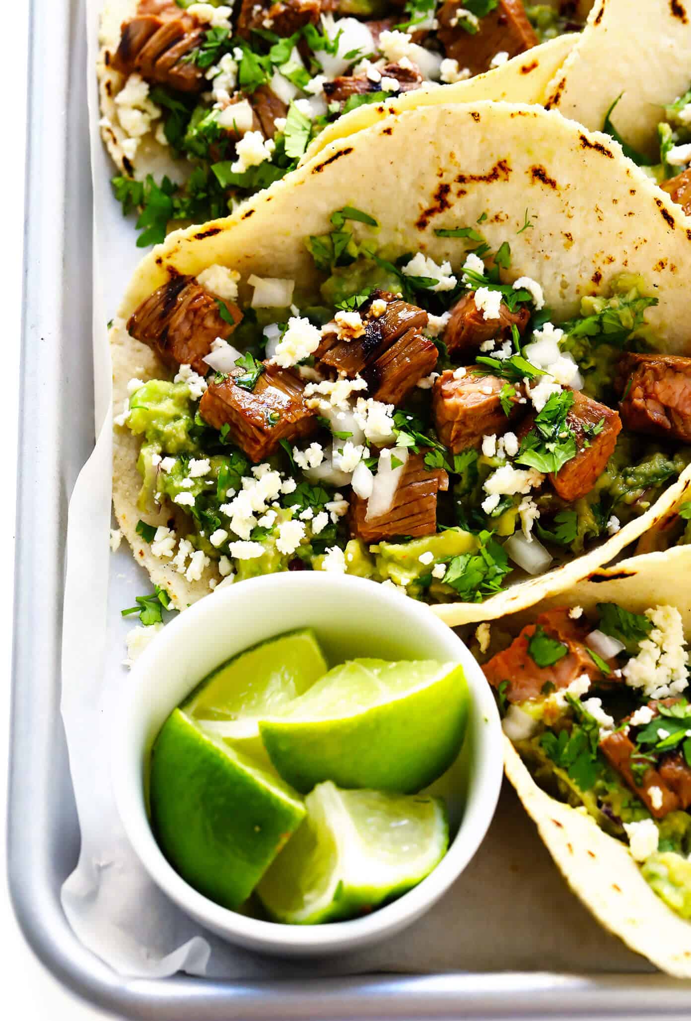 My favorite recipe for street-style Mexican carne asada tacos -- made with tender marinated grilled steak, soft corn tortillas, guacamole or sliced avocado, and whatever other toppings sound good! | gimmesomeoven.com #carneasada #beef #steak #tacos #mexican #avocado #guacamole #glutenfree #dinner Carne Asada Tacos with Lime