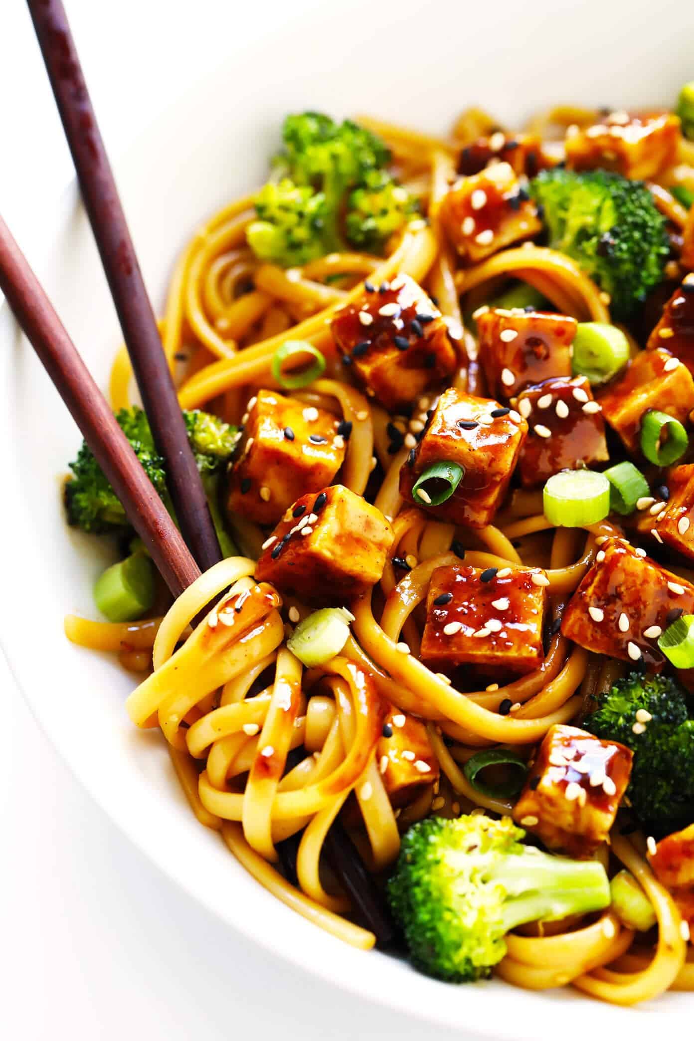 Crispy tofu is tossed with a flavor-packed sweet and savory sauce (made with hoisin, rice vinegar and five spice) and served over my favorite sesame noodles. It's perfect for a weeknight dinner or easy meal prep! (Feel free to use chicken, pork, beef, shrimp, salmon or tempeh in place of the tofu if you prefer.) | gimmesomeoven.com #tofu #noodles #sesame #asian #broccoli #dinner #healthy #vegan #vegetarian #healthy #mealprep #bowl #stirfry Five Spice Tofu Bowls with Sesame Noodles