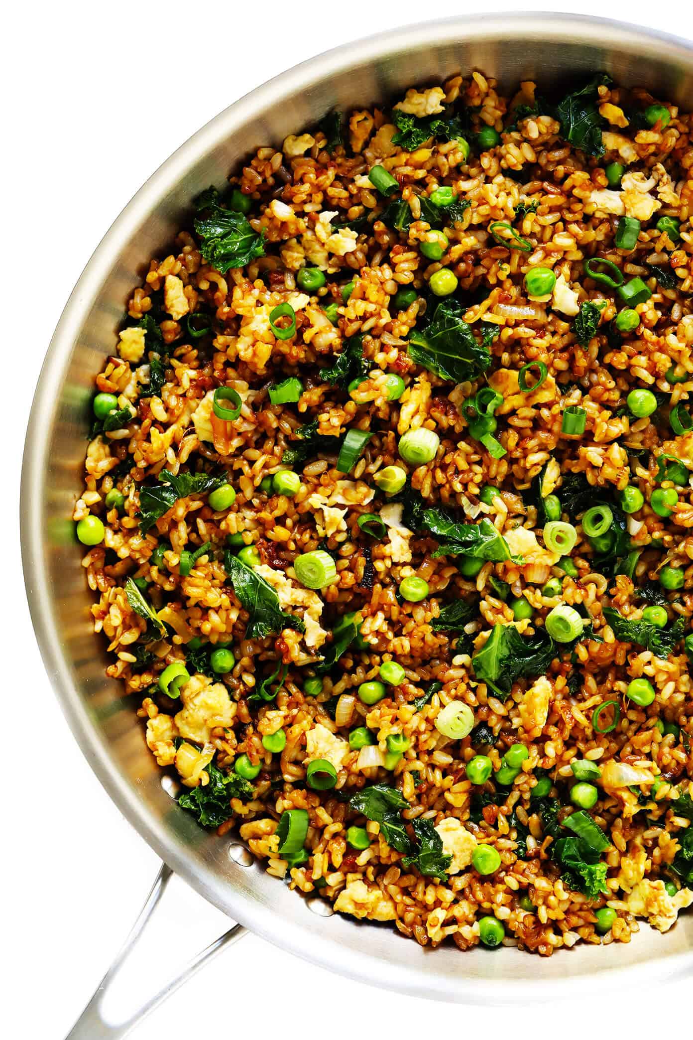 This ginger kale fried rice recipe is quick and easy to make, full of great garlicky ginger flavor, and pan-fried until the rice is extra-crispy! Feel free to add in extra protein (chicken, shrimp, tofu, etc) or extra veggies if you would like. | gimmesomeoven.com #rice #friedrice #dinner #healthy #vegetarian #glutenfree #vegan Ginger Kale Fried Brown Rice in Skillet