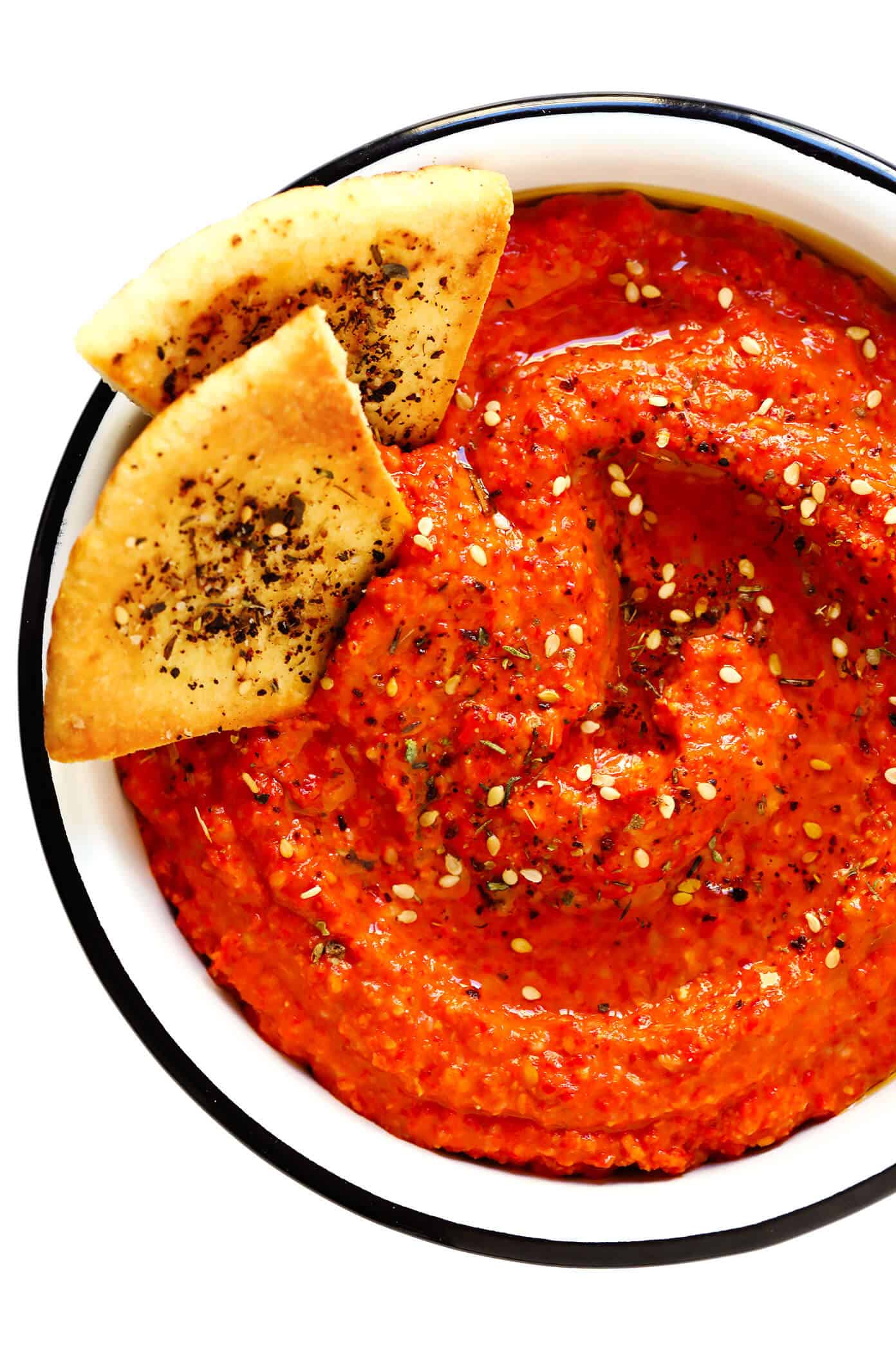 This Muhammara recipe is easy to make in about 10 minutes, made with roasted red peppers and walnuts, and seasoned with lemon, garlic, pomegranate molasses, and a delicious blend of earthy seasonings. It's the perfect dip or spread to serve as an appetizer, or use it as a sauce for chicken, fish, veggies, or whatever sounds good! | gimmesomeoven.com #muhammara #dip #spread #syrian #healthy #vegan #appetizer #mezze Muhammara Dip with Pita Bread