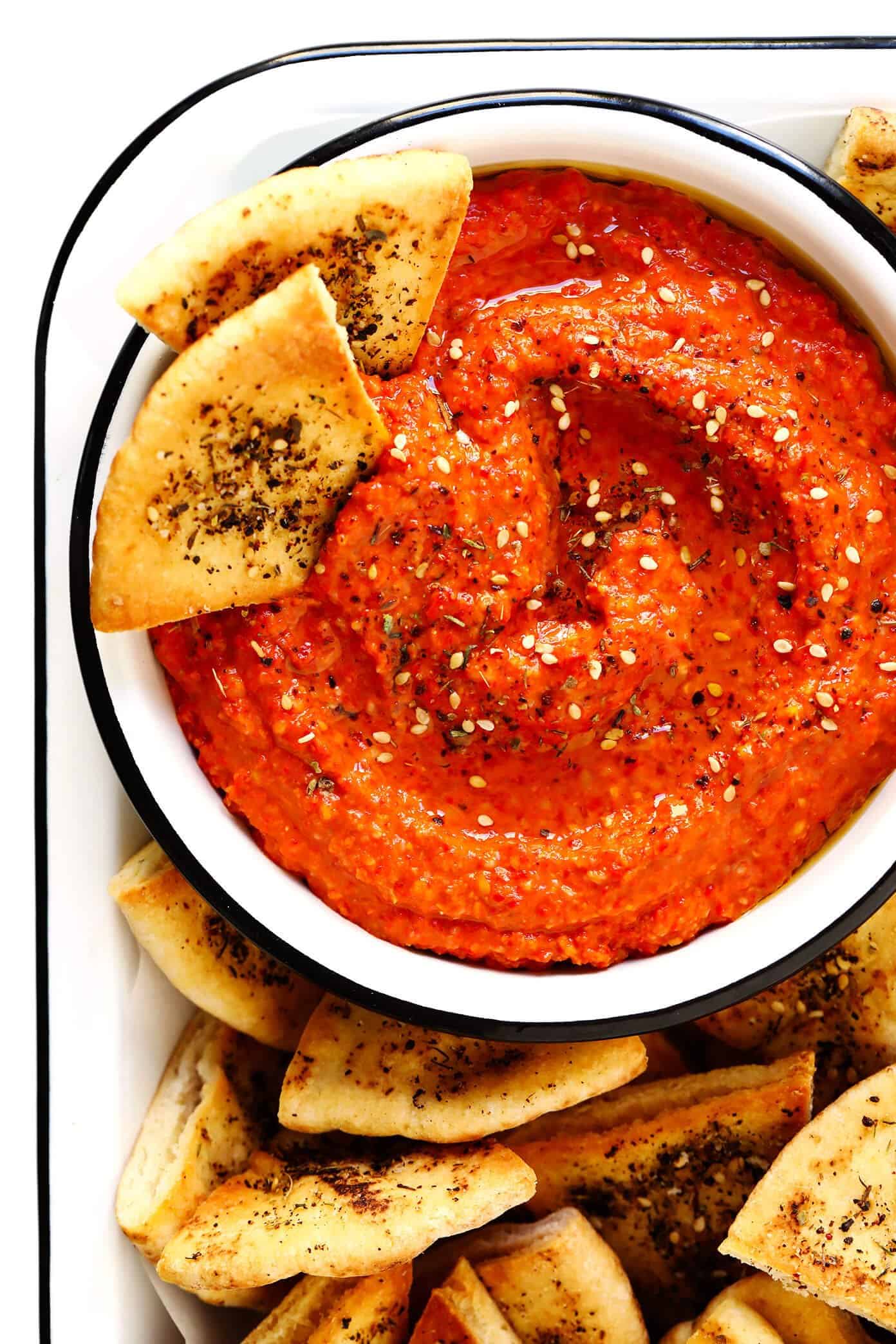 This Muhammara recipe is easy to make in about 10 minutes, made with roasted red peppers and walnuts, and seasoned with lemon, garlic, pomegranate molasses, and a delicious blend of earthy seasonings. It's the perfect dip or spread to serve as an appetizer, or use it as a sauce for chicken, fish, veggies, or whatever sounds good! | gimmesomeoven.com #muhammara #dip #spread #syrian #healthy #vegan #appetizer #mezze Muhammara with Za'atar Pita Chips