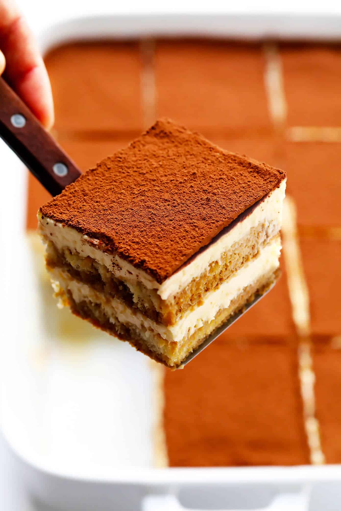 This tiramisu recipe is easy to whip up, this version is made with cooked (instead of raw) eggs, and it tastes just as indulgent and delicious as ever. The perfect make-ahead dessert for Italian night! | gimmesomeoven.com #tiramisu #italian #dessert #mascarpone #nobake #chocolate #vegetarian Slice of tiramisu