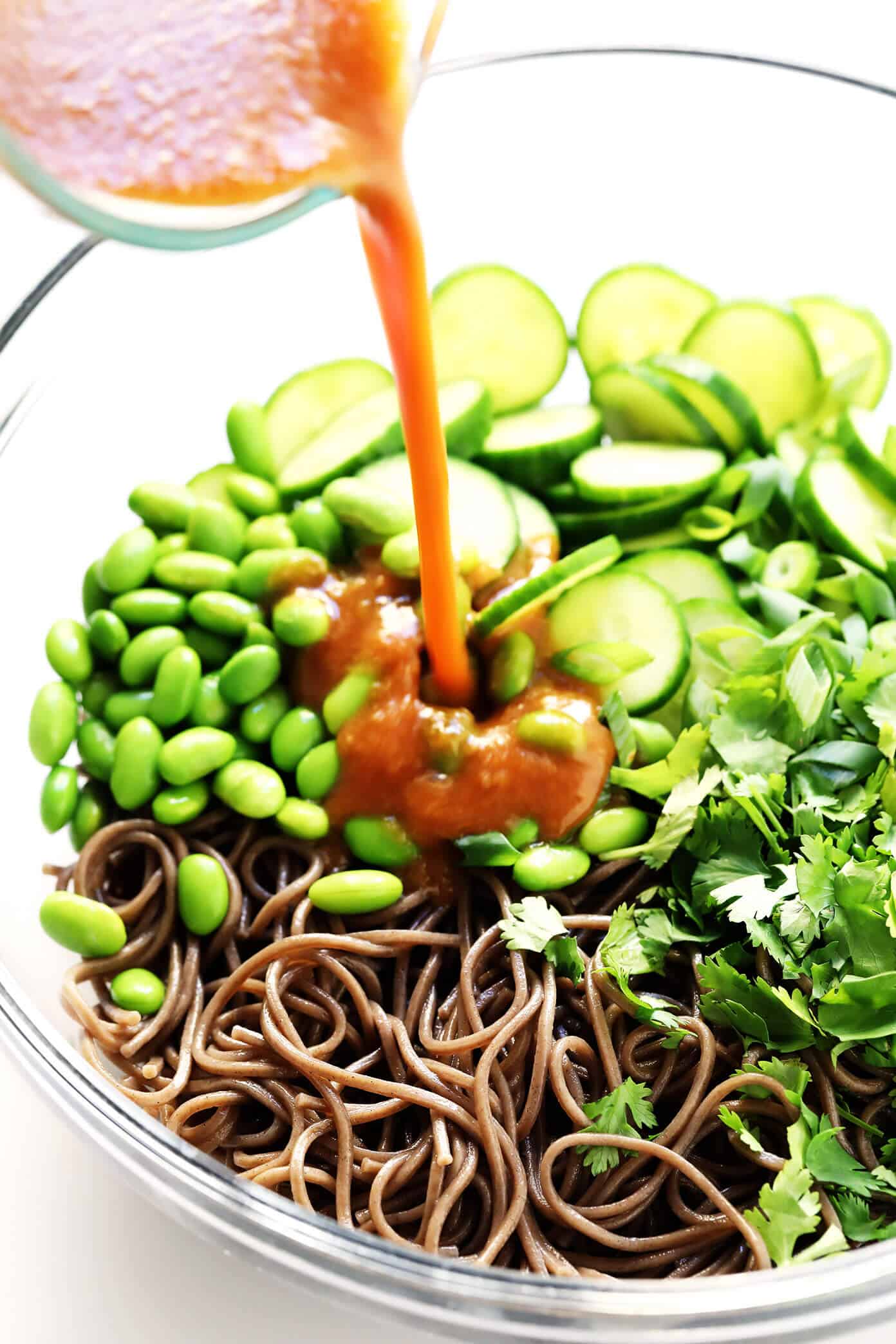 These chilled peanut soba noodles are tossed with cucumber, edamame, fresh herbs and an irresistible peanut sauce...and ready to go in just 20 minutes! Feel free to add extra veggies or a protein (salmon, shrimp, chicken, etc) if you would like. | gimmesomeoven.com #soba #noodles #pasta #salad #healthy #mealprep #glutenfree #vegetarian #vegan #dinner Soba Noodle Salad with Peanut Sauce Drizzled In