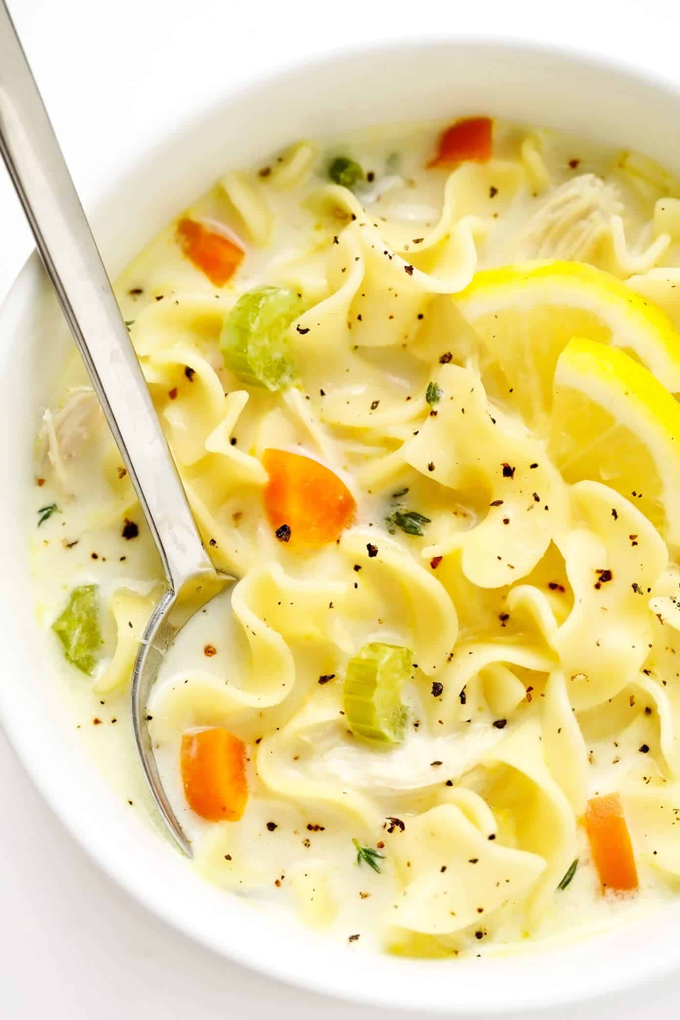 This creamy lemon chicken noodle soup is made with all of the classic ingredients we all love and a cozy creamy broth that's brightened up with lots of fresh lemon juice and thyme. So comforting and delicious! | gimmesomeoven.com #chicken #noodle #soup #creamy #lemon #dinner #winter #onepot #healthy Closeup of Creamy Lemon Chicken Noodle Soup