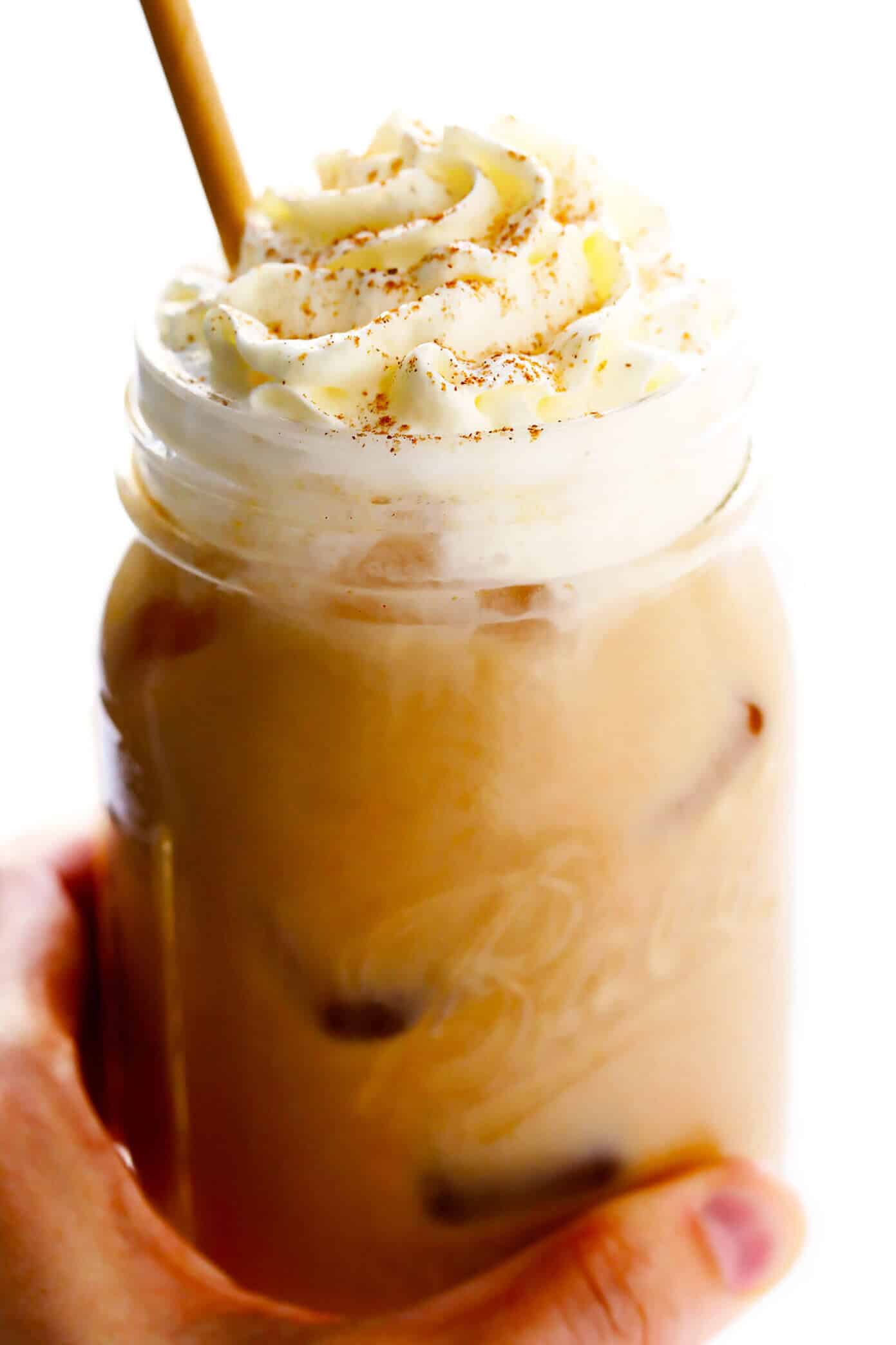 My favorite Iced Pumpkin Spice Latte recipe is made with real pumpkin puree, your choice of milk (dairy or vegan), and naturally sweetened with just a hint of maple syrup. Easy to make in 5 minutes and considerably cheaper than the coffee shop version! | gimmesomeoven.com #pumpkin #latte #coffee #drink #vegan #glutenfree #psl #iced #cold #fall #autumn #winter Iced Pumpkin Spice Latte with Whipped Cream