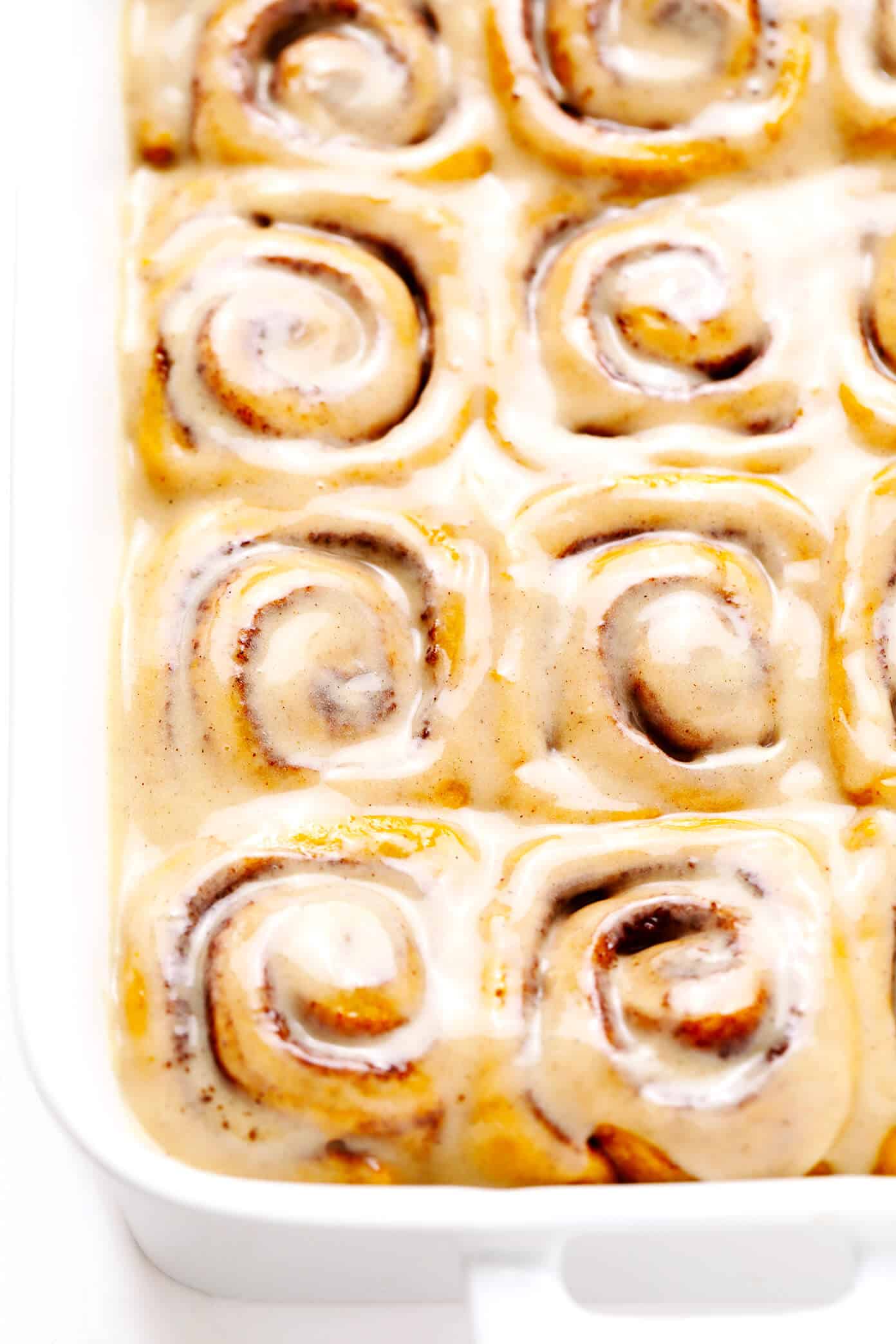 These pumpkin cinnamon rolls are perfectly delicious, soft, chewy and topped with a heavenly maple cream cheese frosting. Easy to make and ready to go in just around 1 hour! | gimmesomeoven.com #pumpkin #cinnamon #rolls #buns #breakfast #brunch #pumpkinspice #fallPu Pumpkin Cinnamon Rolls with Maple Frosting In Pan