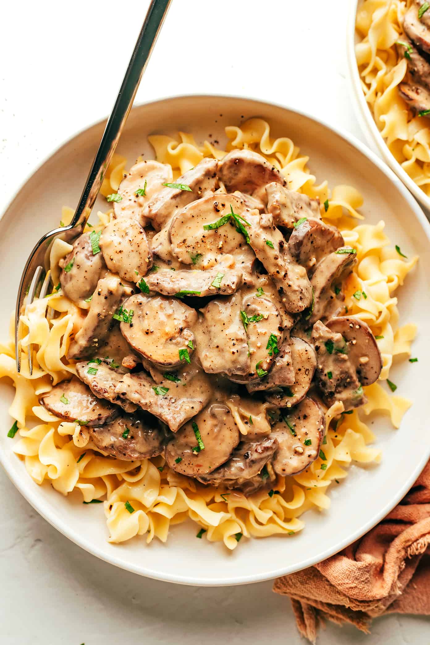 This easy beef stroganoff recipe is made with the most delicious garlicky creamy mushroom sauce and can be ready to go in just 30 minutes. Serve for dinner over noodles, rice, or polenta and enjoy! | gimmesomeoven.com Beef stroganoff with noodles in bowl