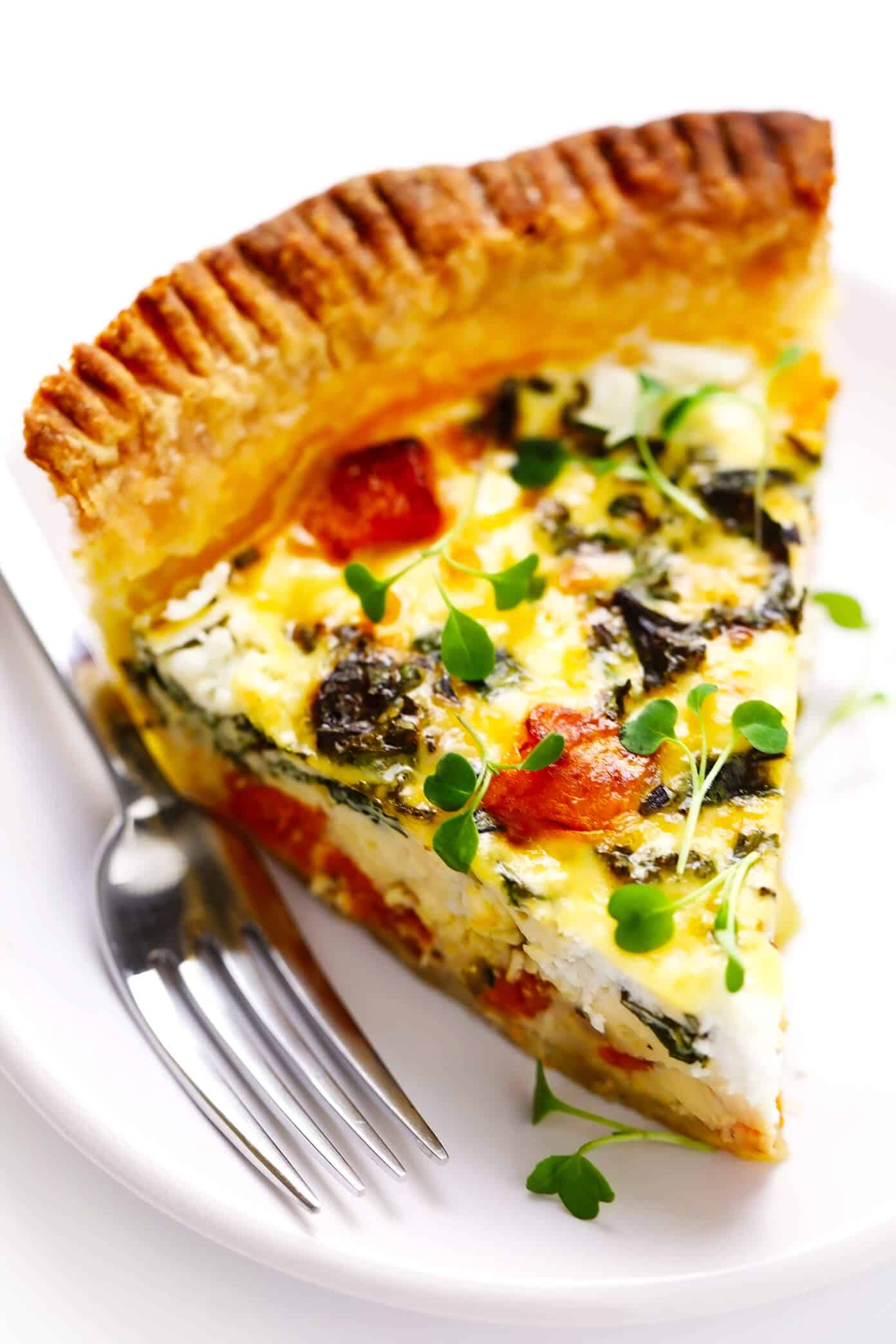 This easy-to-make butternut squash quiche is filled with garlicky kale, goat cheese, rosemary, creamy eggs, and baked in an all-butter pie crust. It's the perfect vegetarian recipe for weekend or holiday brunch and SO delicious. | gimmesomeoven.com #butternut #squash #quiche #breakfast #brunch #egg #bake #vegetarian #thanksgiving #christmas Slice of Butternut Squash Quiche on a Plate