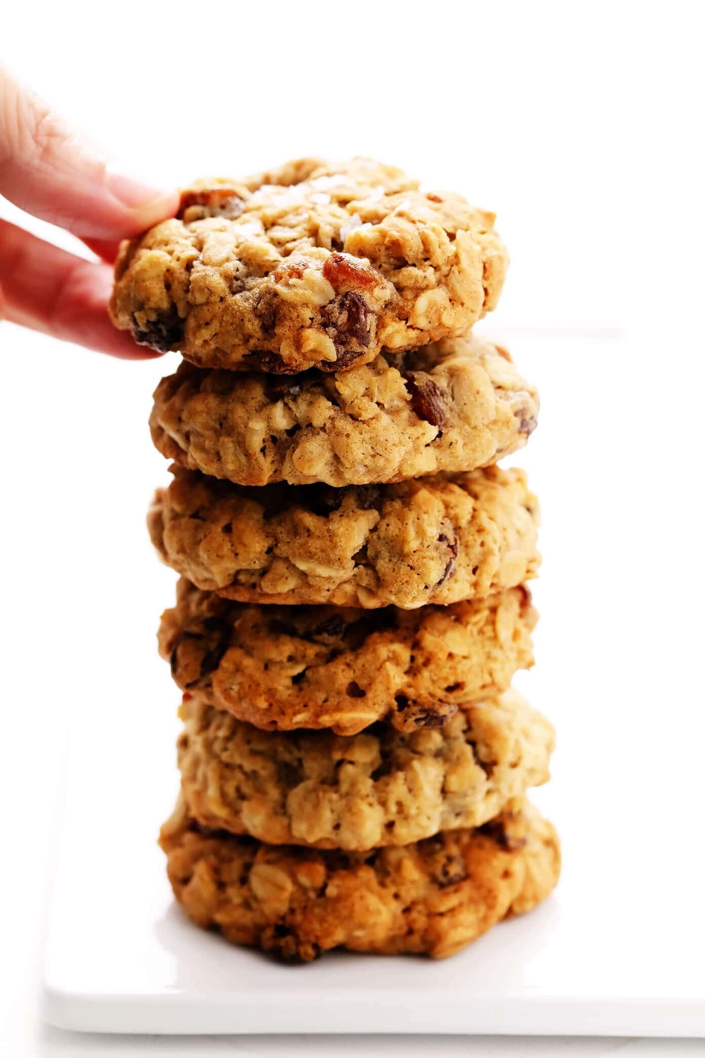 My favorite oatmeal cookies recipe that's perfectly soft and chewy, easy to make, and full of the best oatmeal cinnamon flavors. Perfect for Christmas, holiday baking, or anytime you're craving a chewy cookie. Feel free to add raisins, chocolate chips or nuts too if you would like! | gimmesomeoven.com Stack of Oatmeal Cookies with Raisins