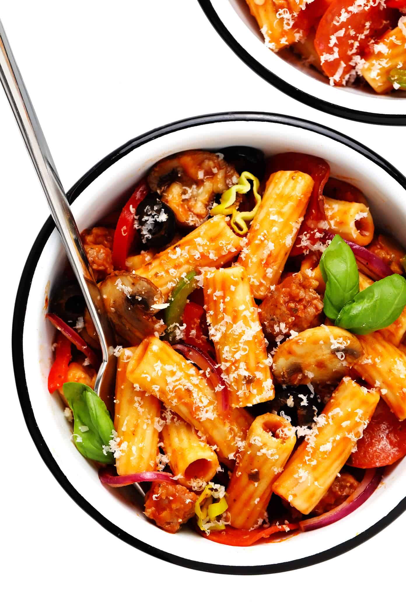 This "Pizza" Baked Ziti recipe is totally fun to make with all of your favorite pizza toppings! Simply bake them up with your favorite pasta, marinara sauce and cheeses, then serve up this casserole while it's hot and bubbly for a delicious Italian dinner! Feel free to use gluten-free, vegetarian and/or vegan ingredients if you prefer. | gimmesomeoven.com #pizza #pasta #bakedziti #casserole #bake #italian #dinner #easy #vegetarian #glutenfree Pizza Baked Ziti in Serving Bowl