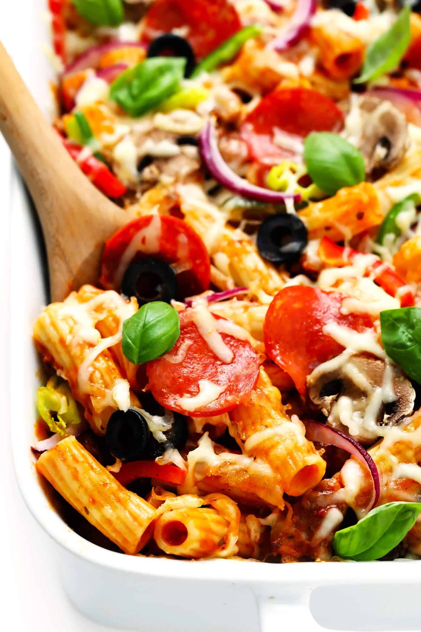 This "Pizza" Baked Ziti recipe is totally fun to make with all of your favorite pizza toppings! Simply bake them up with your favorite pasta, marinara sauce and cheeses, then serve up this casserole while it's hot and bubbly for a delicious Italian dinner! Feel free to use gluten-free, vegetarian and/or vegan ingredients if you prefer. | gimmesomeoven.com #pizza #pasta #bakedziti #casserole #bake #italian #dinner #easy #vegetarian #glutenfree Scoop of Pepperoni Pizza Baked Ziti