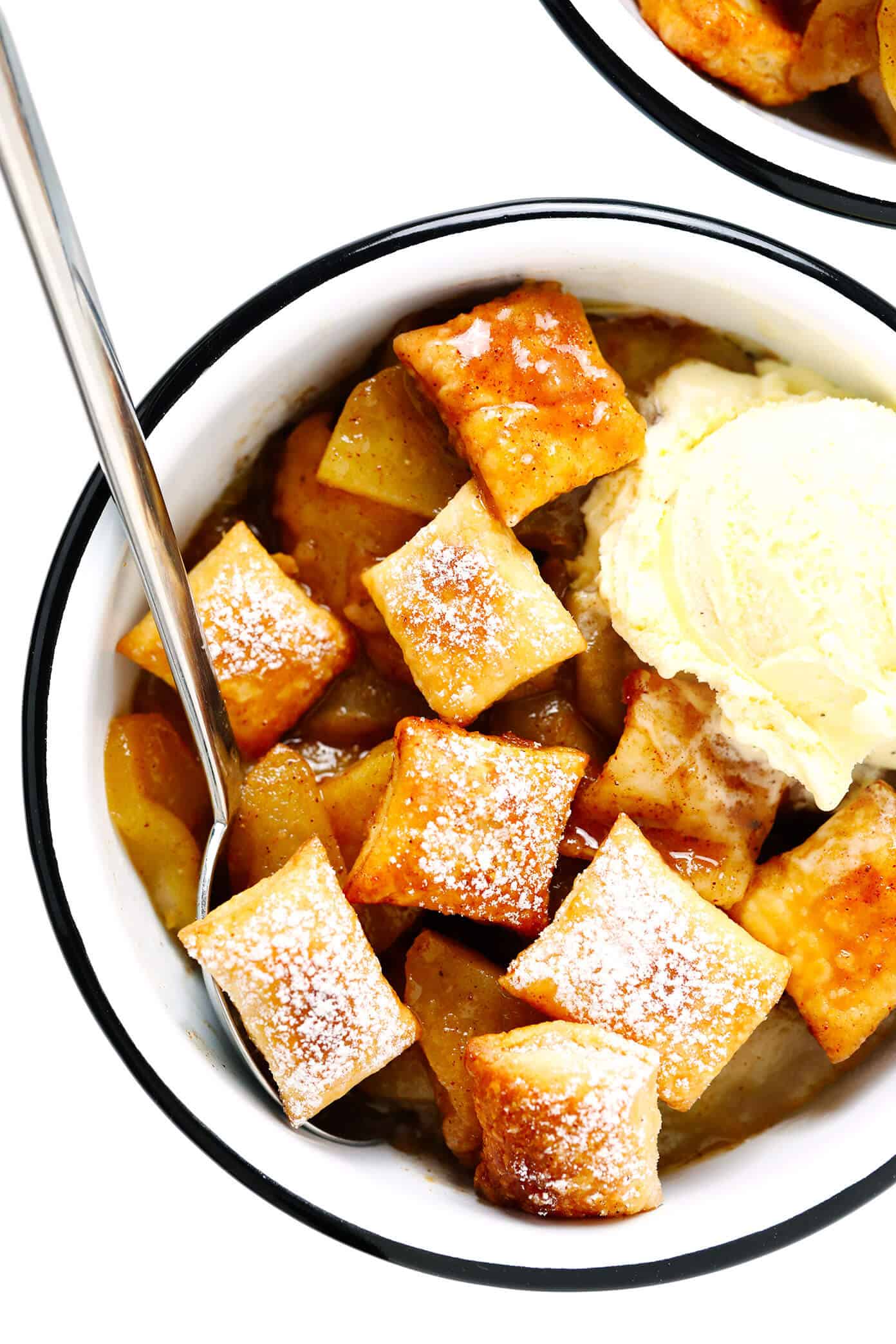 This easy Apple Pandowdy recipe is made with a delicious baked apple cinnamon pie filling topped with toasted puff pastry bites and a light dusting of powdered sugar. Absolutely delicious served warm with vanilla ice cream, and the perfect dessert for the holidays. | gimmesomeoven.com #apple #pandowdy #pie #dessert #bake #crisp #puffpastry #filling #thanksgiving #christmas Apple Pandowdy in Bowls with Vanilla Ice Cream