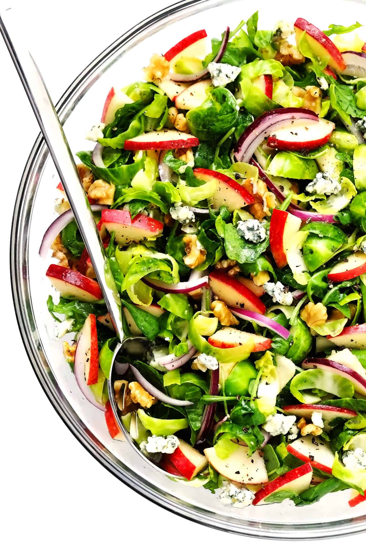 This shredded Brussels Sprouts Salad recipe is tossed with chopped arugula, sweet apples, crisp red onions, toasted nuts (walnuts, pecans, or almonds), crumbled soft cheese (blue, goat or feta), and my simple everyday salad dressing. Perfect for the holidays or winter weeknights! | gimmesomeoven.com #brussels #apple #salad #healthy #thanksgiving #christmas #holiday #glutenfree #vegetarian #dinner #side Brussels Sprouts Salad with Apples in Mixing Bowl