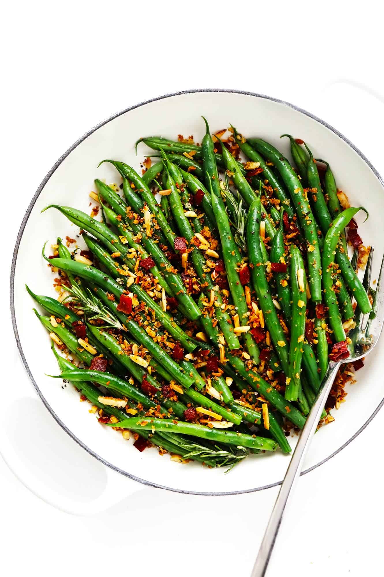 This one-pan sautéed green beans recipe is quick and easy to make and tossed with the most irresistible crispy garlic almond rosemary bacon breadcrumbs. The perfect easy side dish for Thanksgiving, Christmas, or any weeknight dinner! | gimmesomeoven.com #greenbeans #vegetable #side #bacon #thanksgiving #christmas #holiday #glutenfree #dinner Green Beans with Bacon Breadcrumbs in Saute Pan with Fork