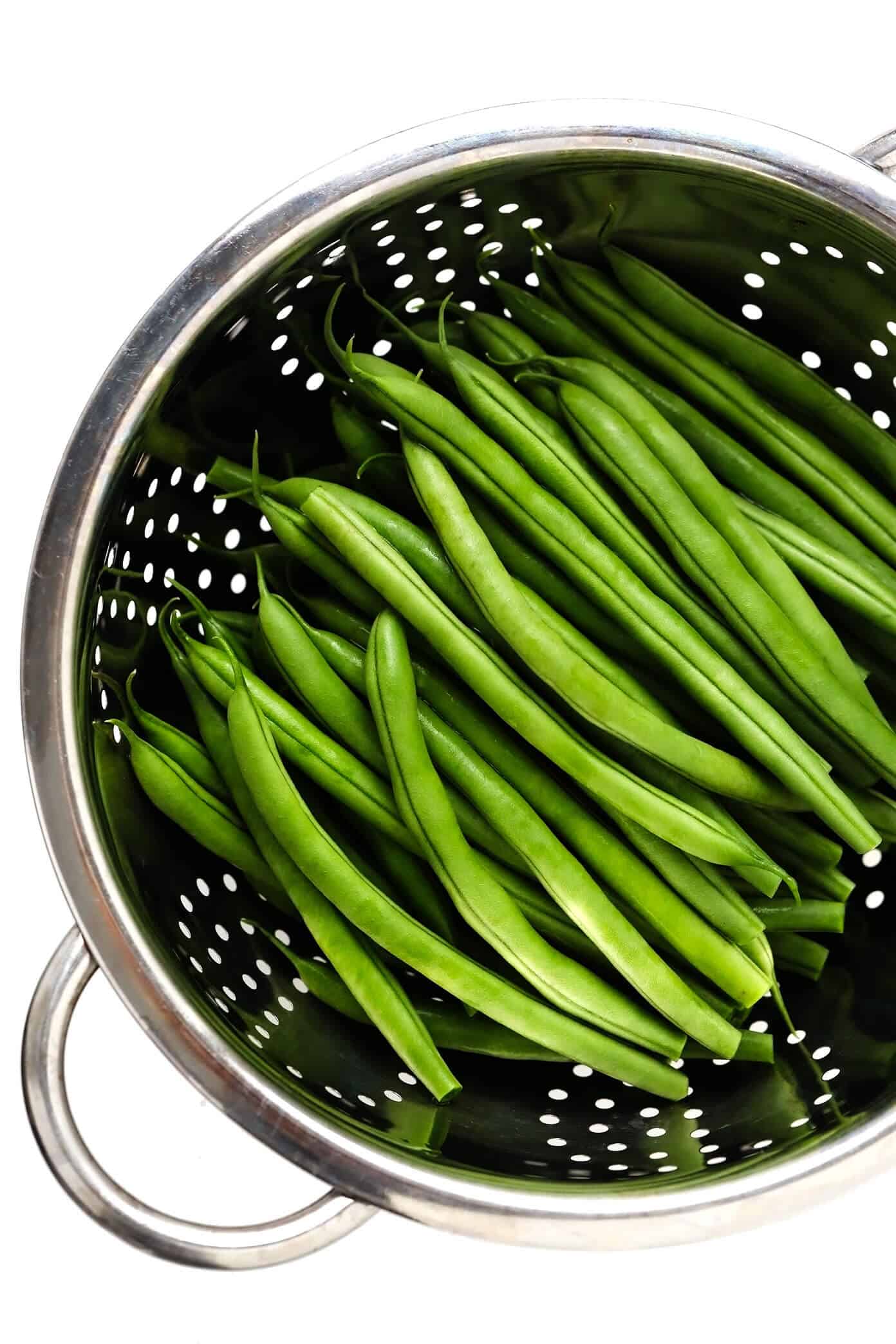 This one-pan sautéed green beans recipe is quick and easy to make and tossed with the most irresistible crispy garlic almond rosemary bacon breadcrumbs. The perfect easy side dish for Thanksgiving, Christmas, or any weeknight dinner! | gimmesomeoven.com #greenbeans #vegetable #side #bacon #thanksgiving #christmas #holiday #glutenfree #dinner Green Beans in Strainer