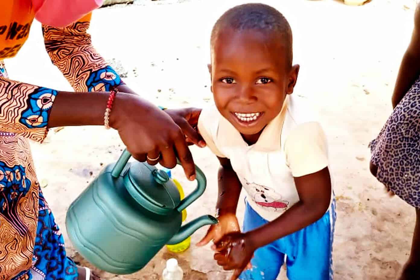 A very special project to build a new community garden with The Wash Project | Gimme Some Oven Young boy in Mali washing his hands with soap and clean water