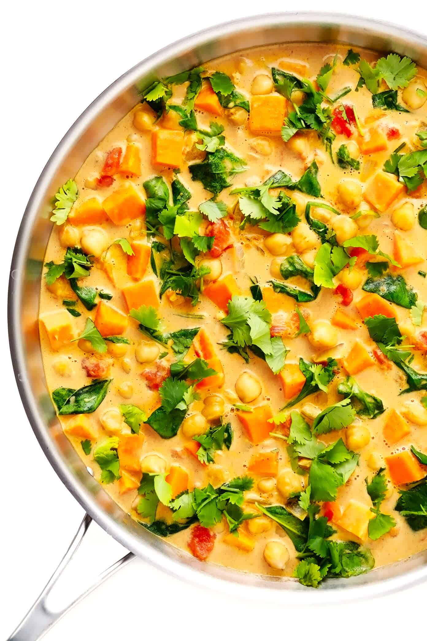 This delicious Sweet Potato Chickpea Coconut Curry recipe is super easy to make, naturally gluten-free, vegetarian and vegan, and it's simmered with tomatoes, garlic, ginger, spinach the coziest creamy coconut curry broth. Goes great with rice and/or naan bread, and tastes amazing for leftovers the next day! | gimmesomeoven.com #curry #healthy #vegetable #vegetarian #vegan #glutenfree #chickpea #sweetpotato #dinner #mealprep #indian Sweet Potato Chickpea Curry in Sauté Pan with Cilantro