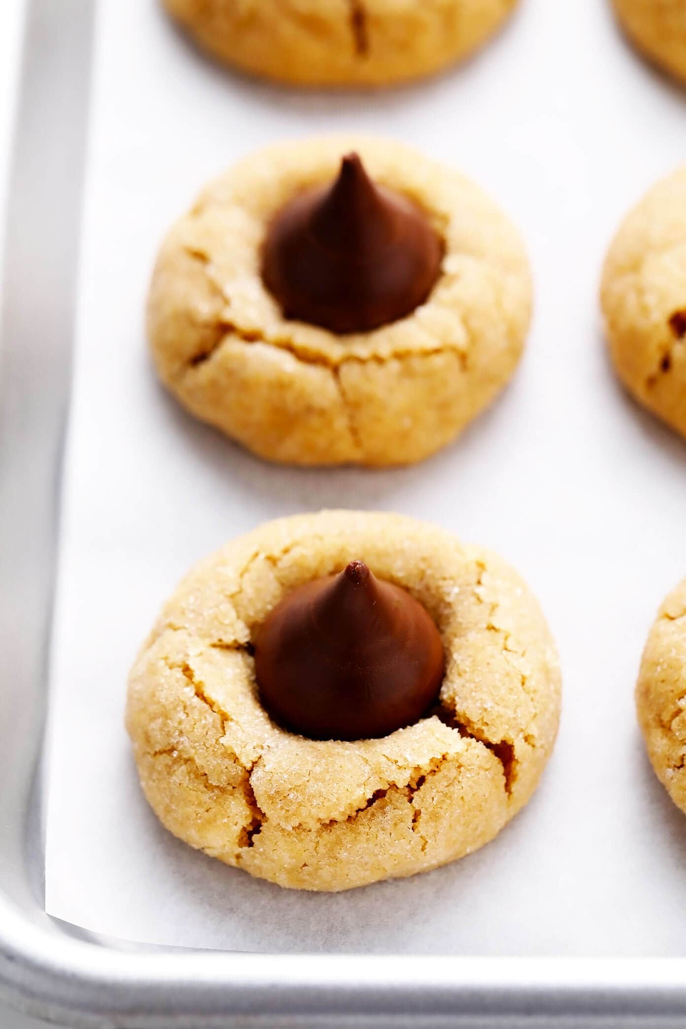 This peanut butter blossoms recipe is made with extra peanut butter, topped with Hershey's Kisses (or peanut butter cups), and perfectly soft and chewy and crackled. Perfect for Christmas or holiday baking, or anytime you have a cookie craving! | gimmesomeoven.com Peanut Butter Blossoms Close-Up