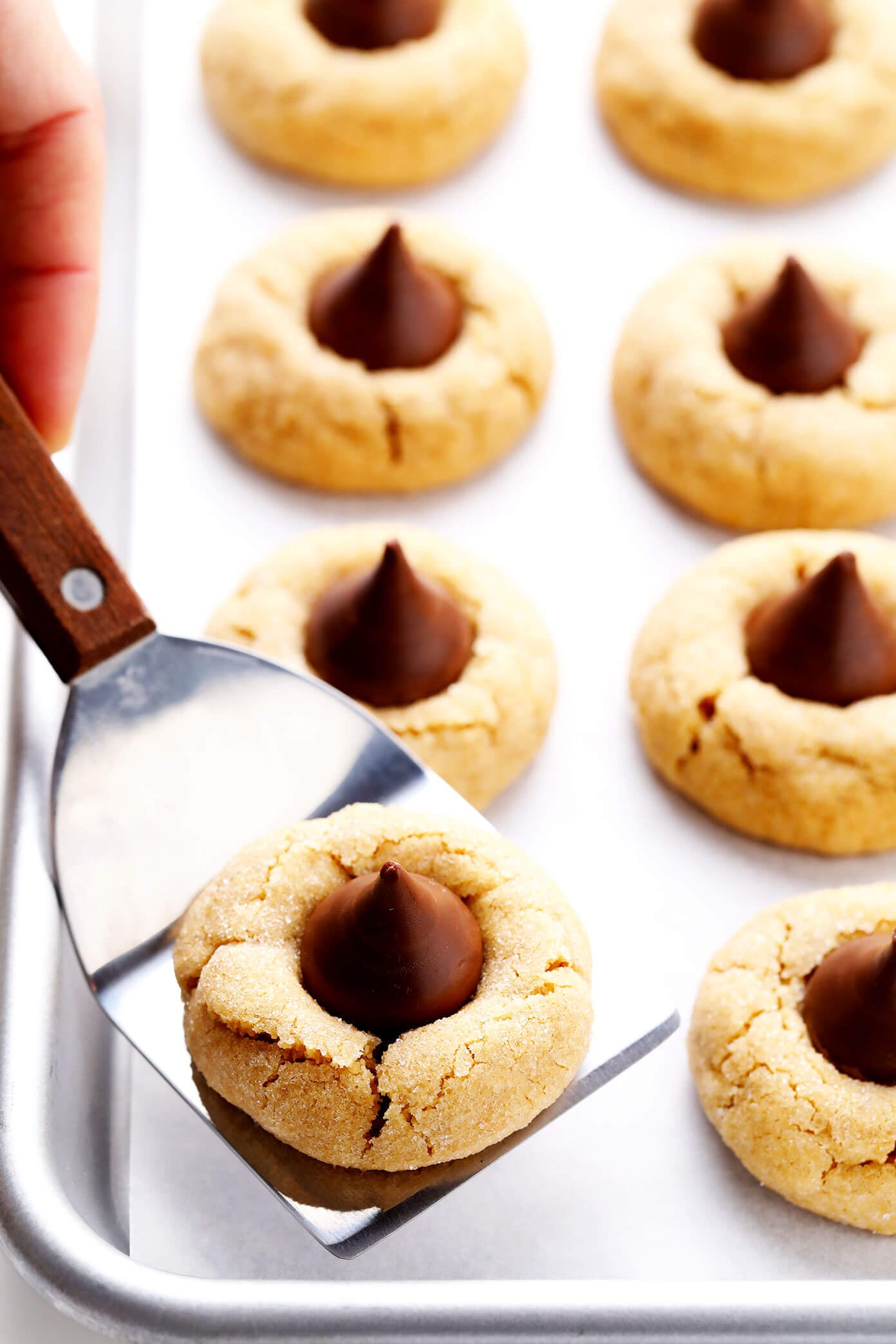 This peanut butter blossoms recipe is made with extra peanut butter, topped with Hershey's Kisses (or peanut butter cups), and perfectly soft and chewy and crackled. Perfect for Christmas or holiday baking, or anytime you have a cookie craving! | gimmesomeoven.com Peanut Butter Blossoms (Hershey's Kiss Cookies)