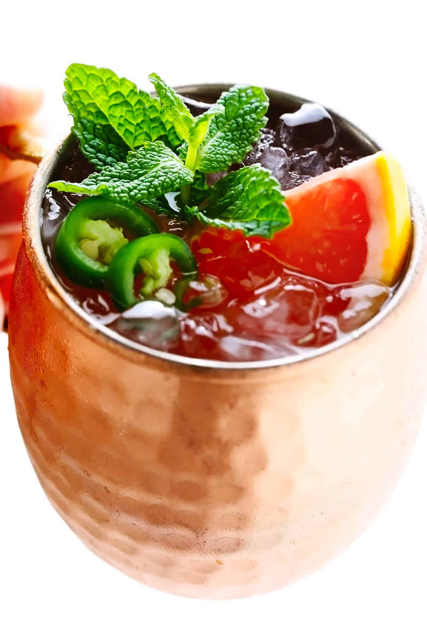 This Spicy Grapefruit Ginger Fizz mocktail is made with grapefruit juice, spicy ginger beer, fresh lime juice, mint, and jalapeño. It's easy to whip up in 5 minutes, minimally sweet, and so flavorful! | gimmesomeoven.com #mocktail #drink #gingerbeer #alcoholfree #grapefruit #spritzer Spicy Grapefruit Ginger Fizz Mocktail in Copper Mug